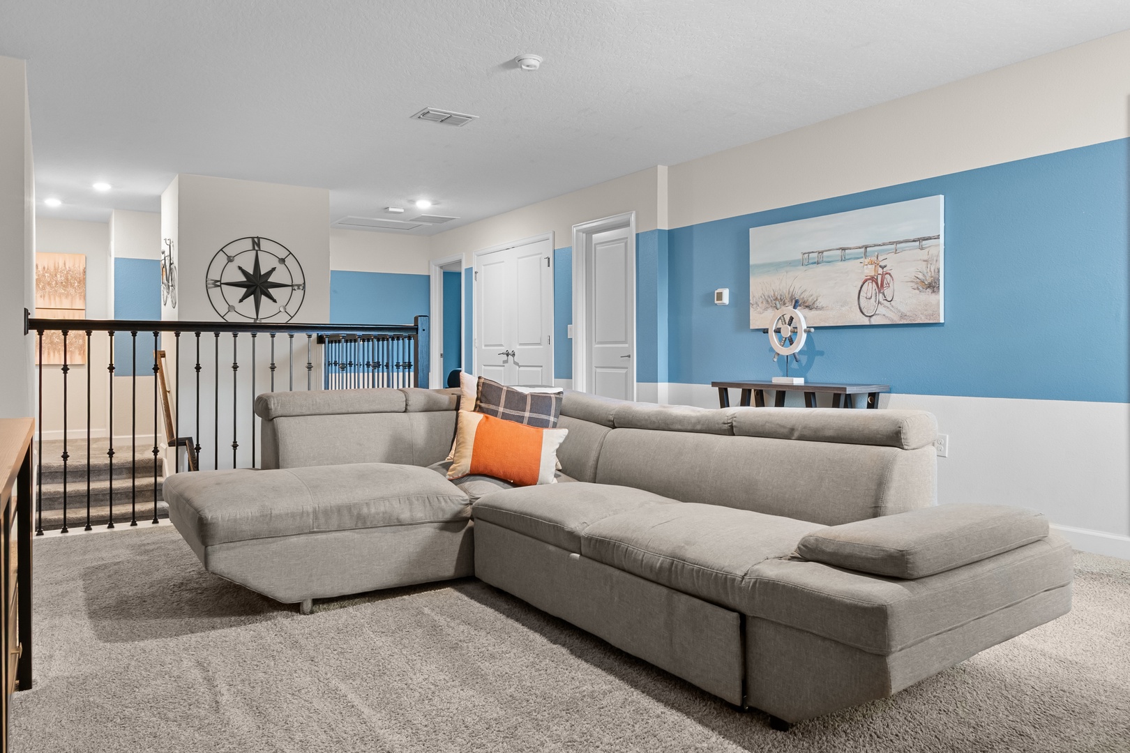 Sink into your spacious sectional and unwind in this coastal-themed living room, where nautical decor and soothing blue walls create the perfect retreat.
