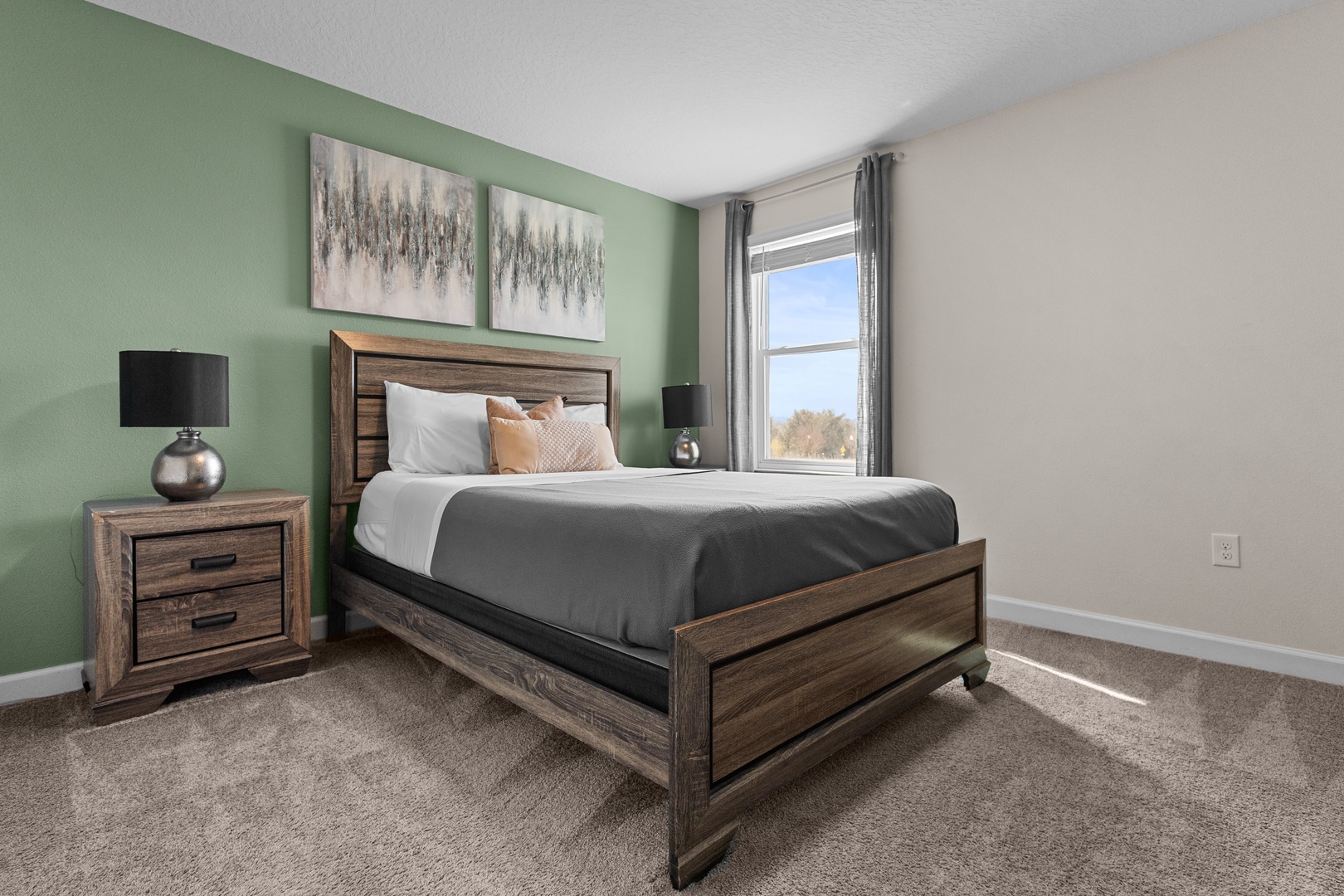 Unwind in your serene bedroom featuring a cozy queen bed, calming sage accent wall, and natural light streaming through your window.