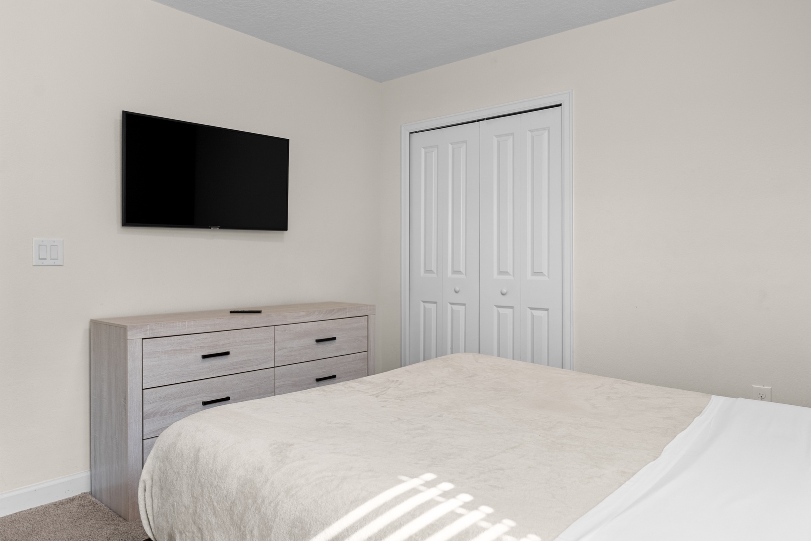 Your modern bedroom features a wall-mounted TV for relaxing entertainment and ample dresser storage for all your belongings.