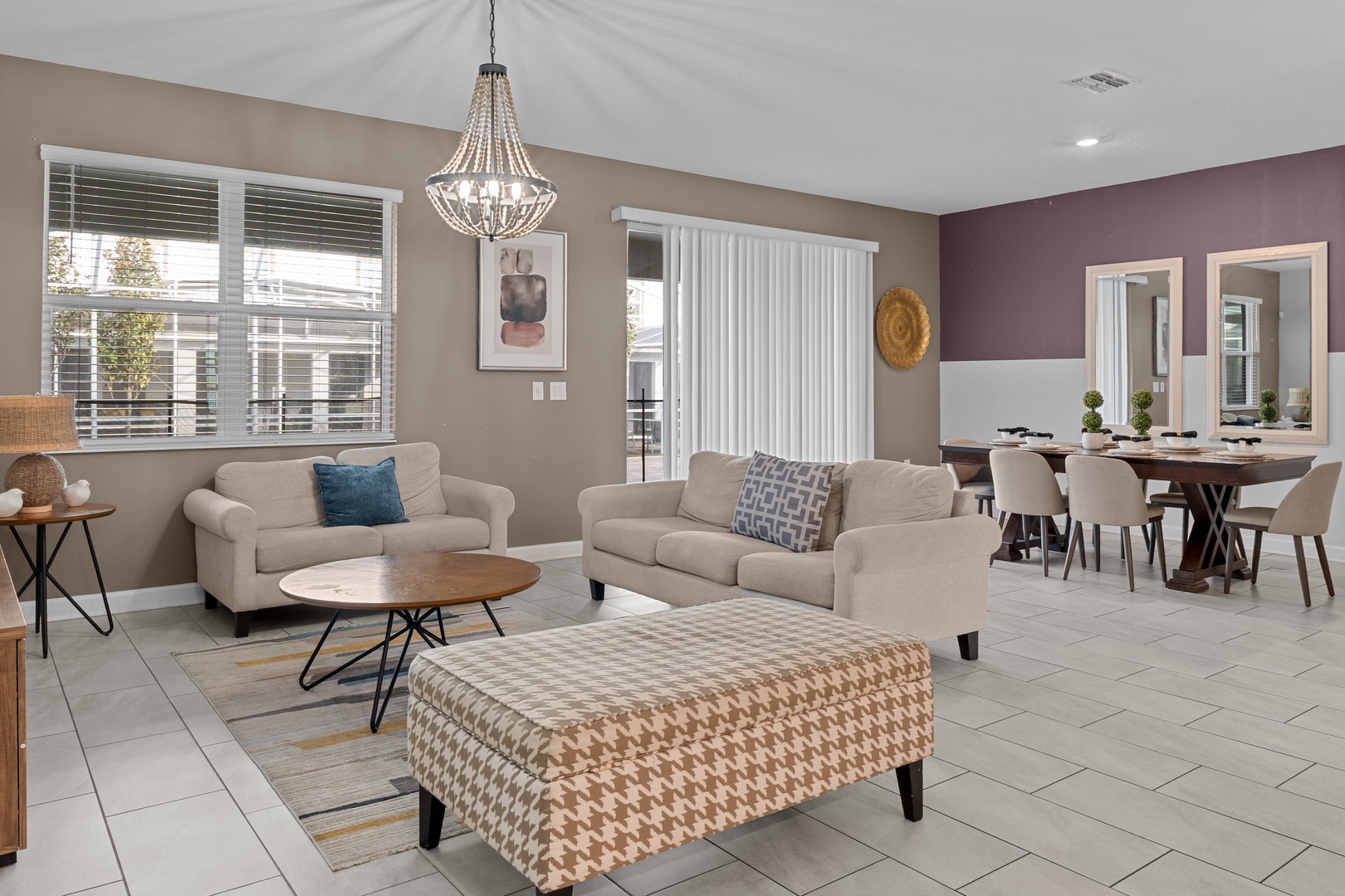 Relax in your stylish open-plan living space with plush seating, elegant chandelier, and seamless flow to your dining area.