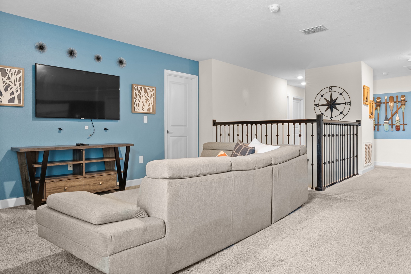 Relax in your spacious loft living area with plush sectional seating, large TV, and stylish coastal decor creating the perfect retreat.