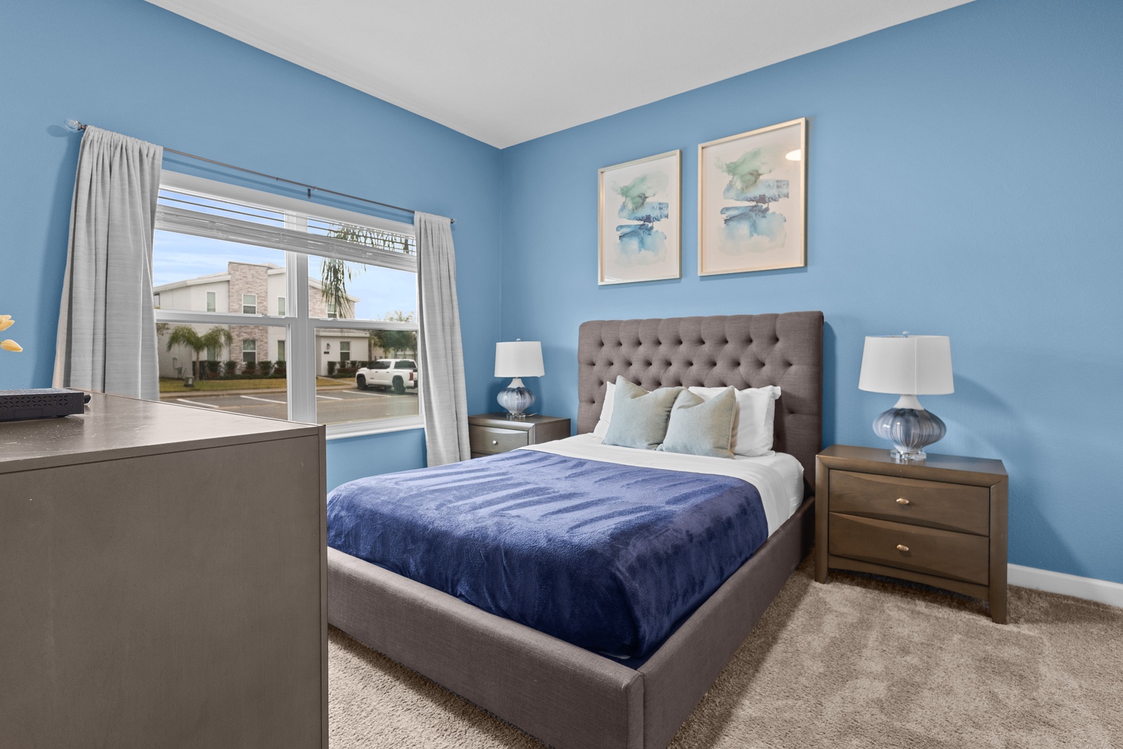 Unwind in your serene blue bedroom with plush bedding and peaceful neighborhood views from your window.