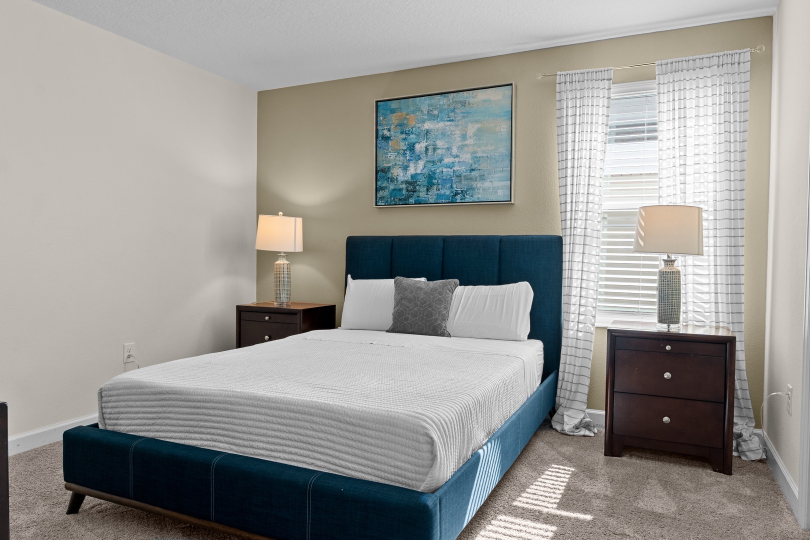 Sink into this plush blue bed surrounded by elegant décor and soft natural light filtering through your windows for perfect relaxation.