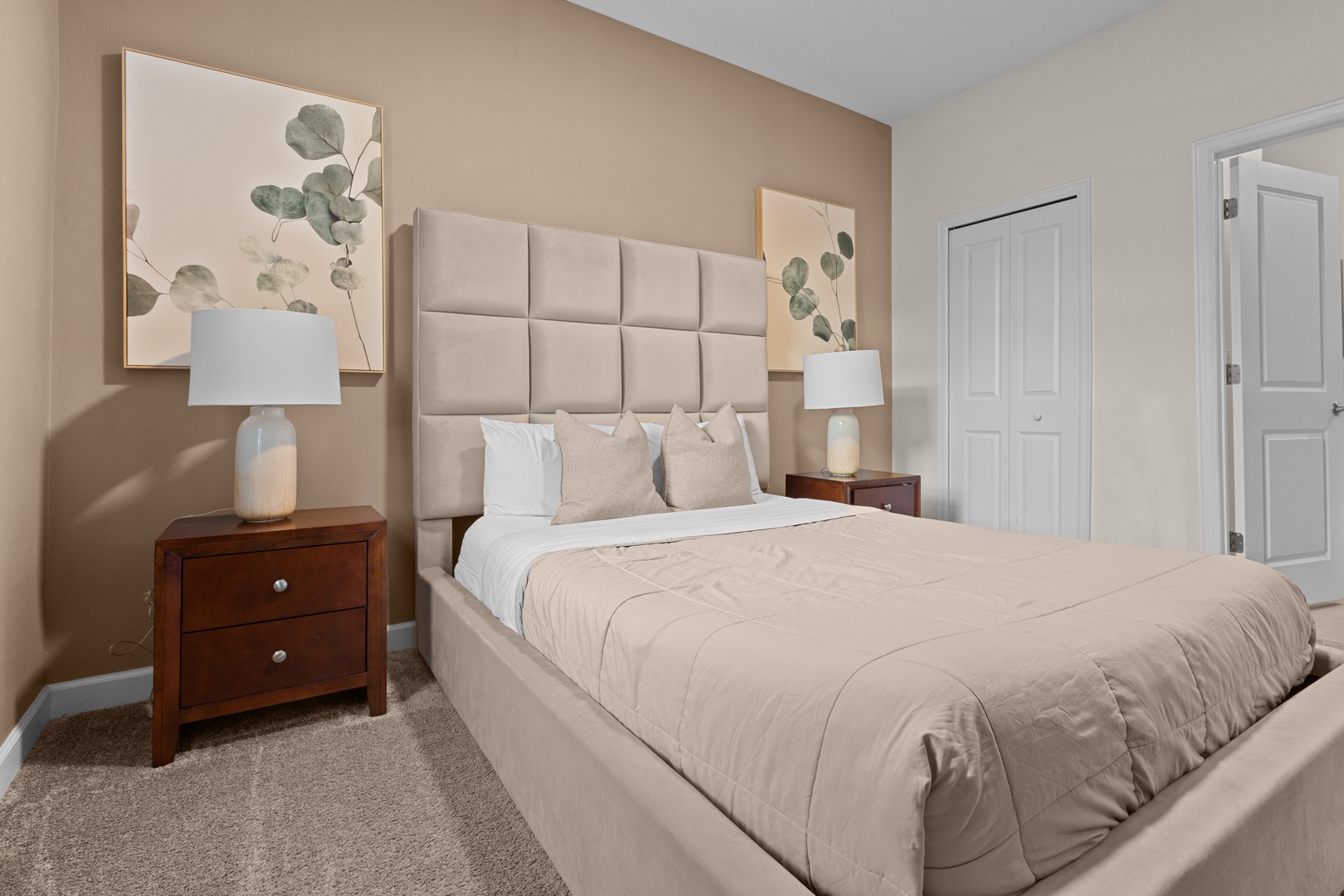 Drift into peaceful sleep in your elegantly appointed bedroom, featuring a plush upholstered headboard and calming botanical artwork.