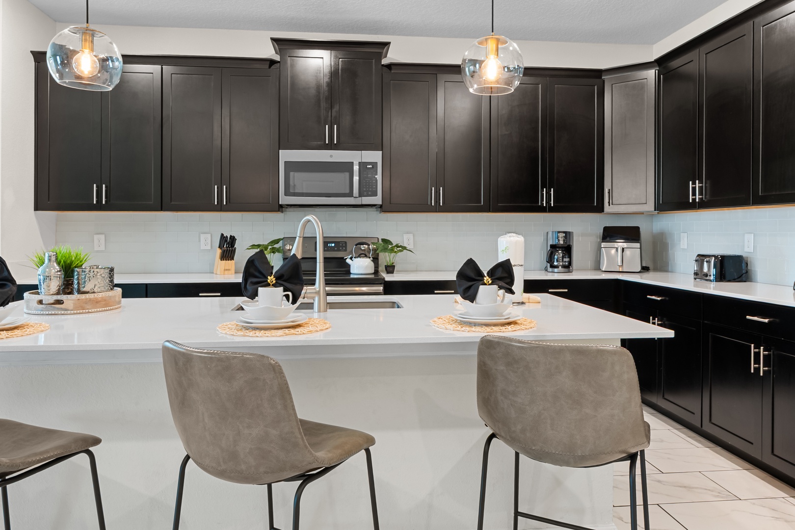 Your sleek kitchen features dark cabinetry, quartz counters, and modern appliances perfect for preparing memorable meals together.