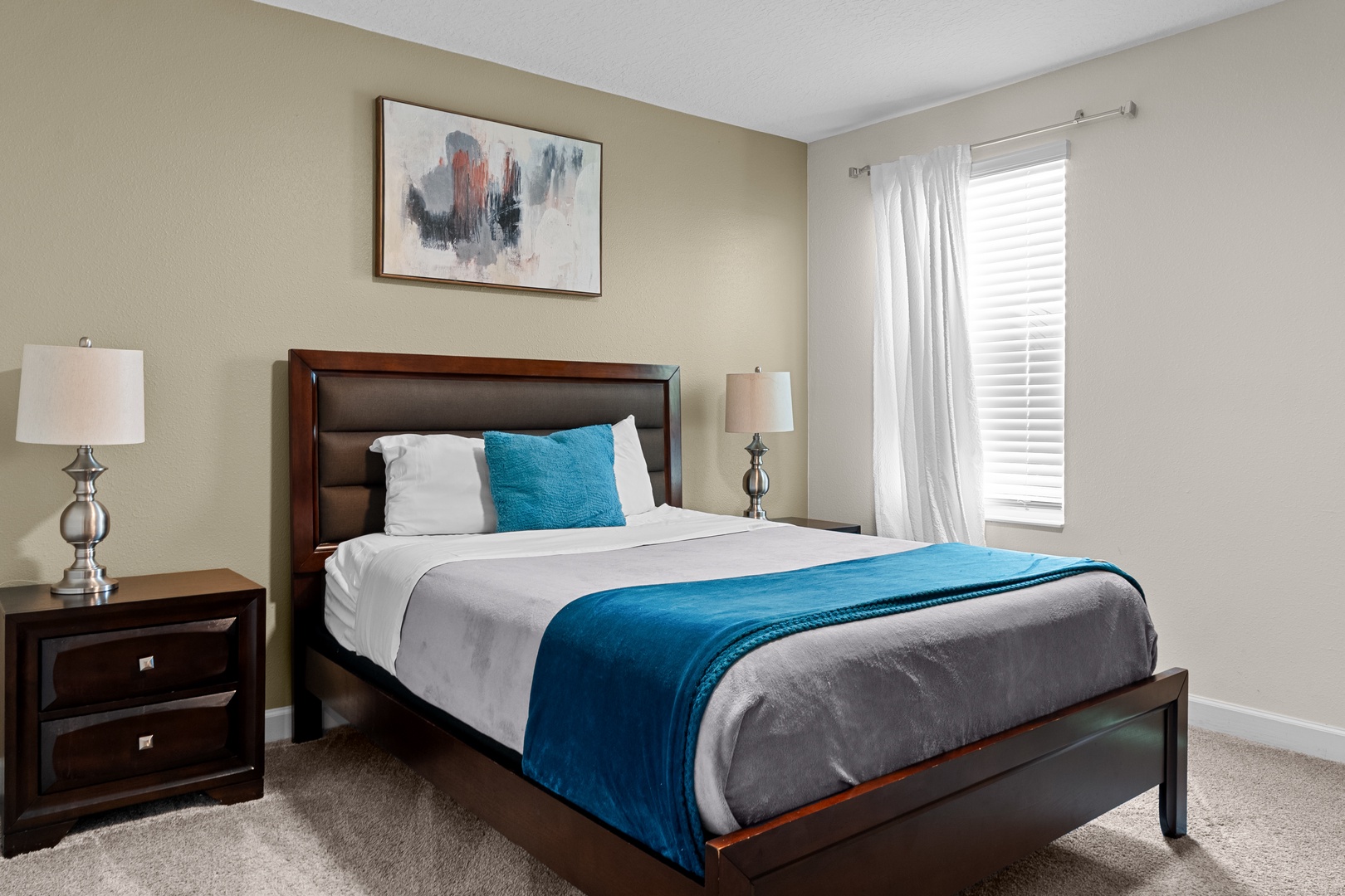 Your peaceful bedroom retreat features a plush bed with crisp linens and vibrant blue accents, perfect for restful nights.