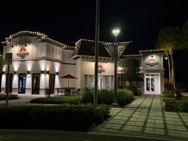 Elegant property entrance illuminated with warm string lights and professional landscaping creates a welcoming first impression.