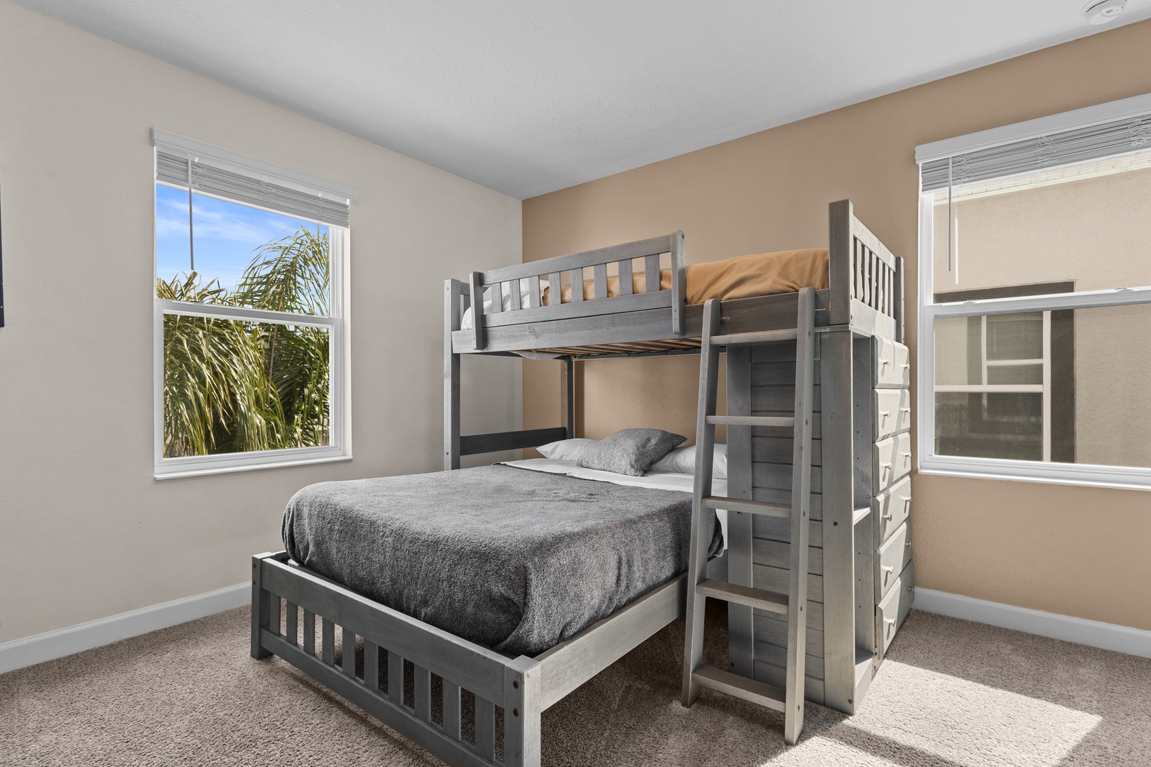Your kids will love this fun bunk bed room with tropical views through bright windows.