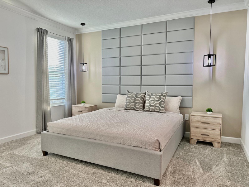 Sink into your serene sanctuary with a plush queen bed, striking tufted headboard, and warm pendant lighting that creates the perfect ambiance for rest.
