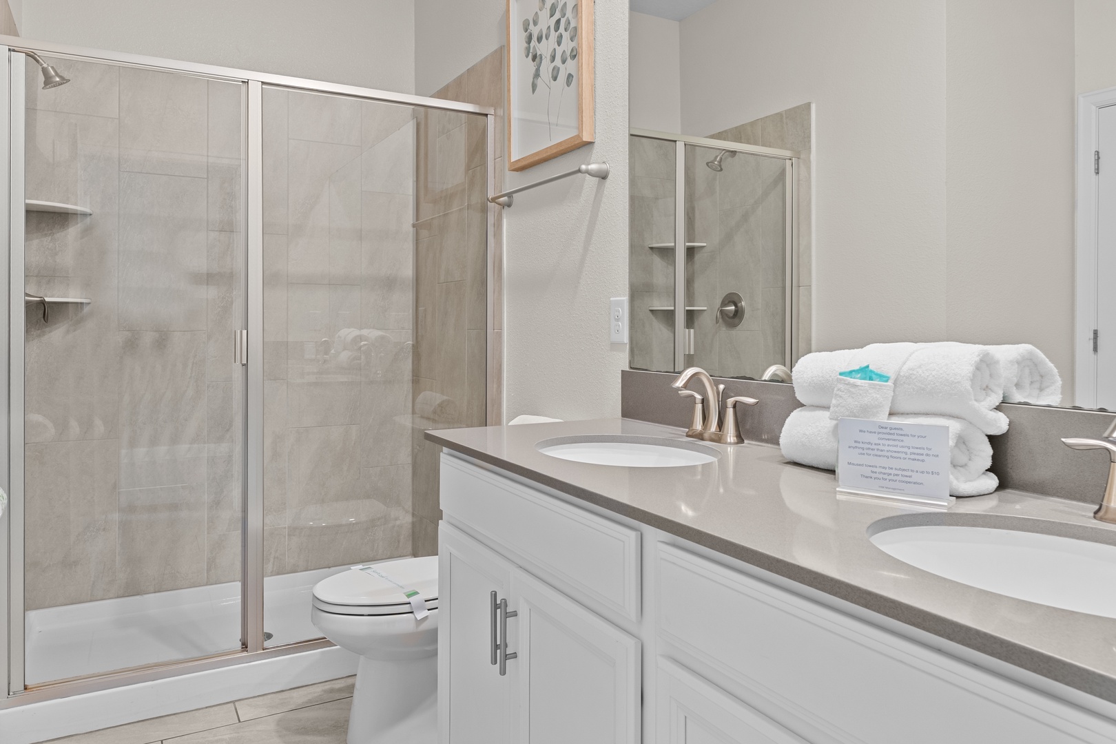 Refresh in your modern bathroom with spacious shower, dual sinks, and plush towels awaiting your arrival.