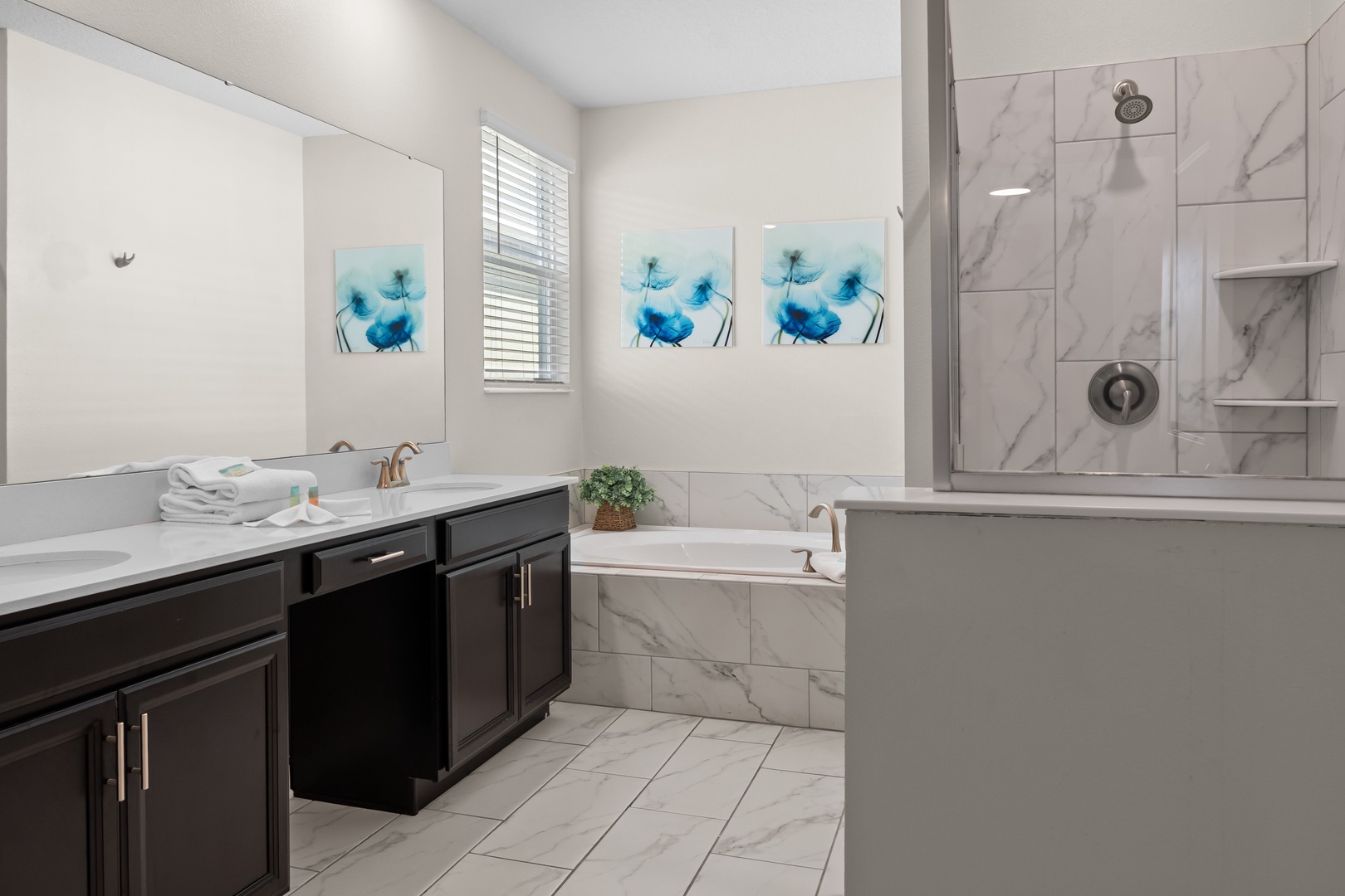 Unwind in your spa-like bathroom featuring elegant marble surfaces, a deep soaking tub, and spacious glass shower.