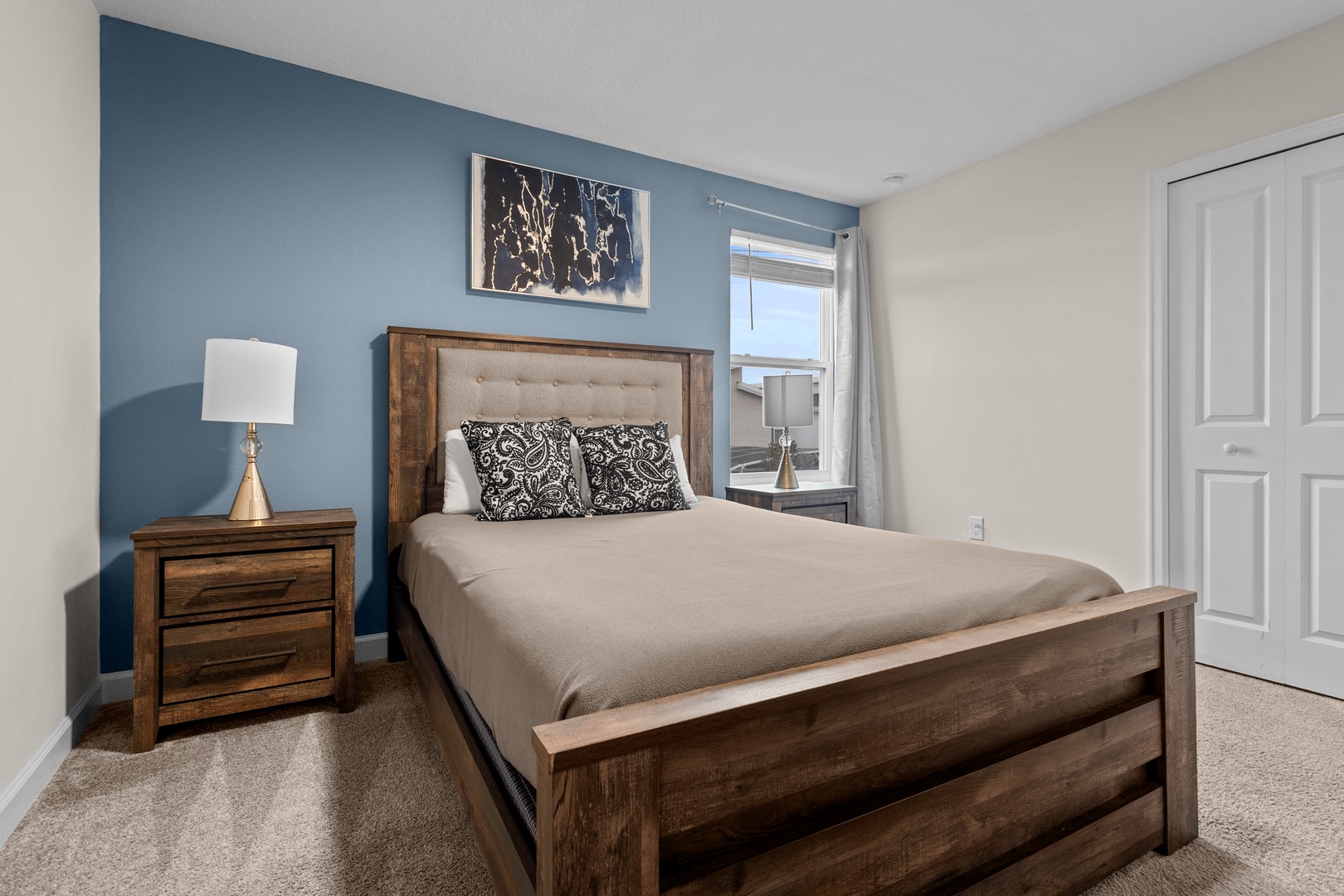 Unwind in your cozy bedroom with rustic wood furnishings and soothing blue accent wall, perfectly positioned for restful nights.