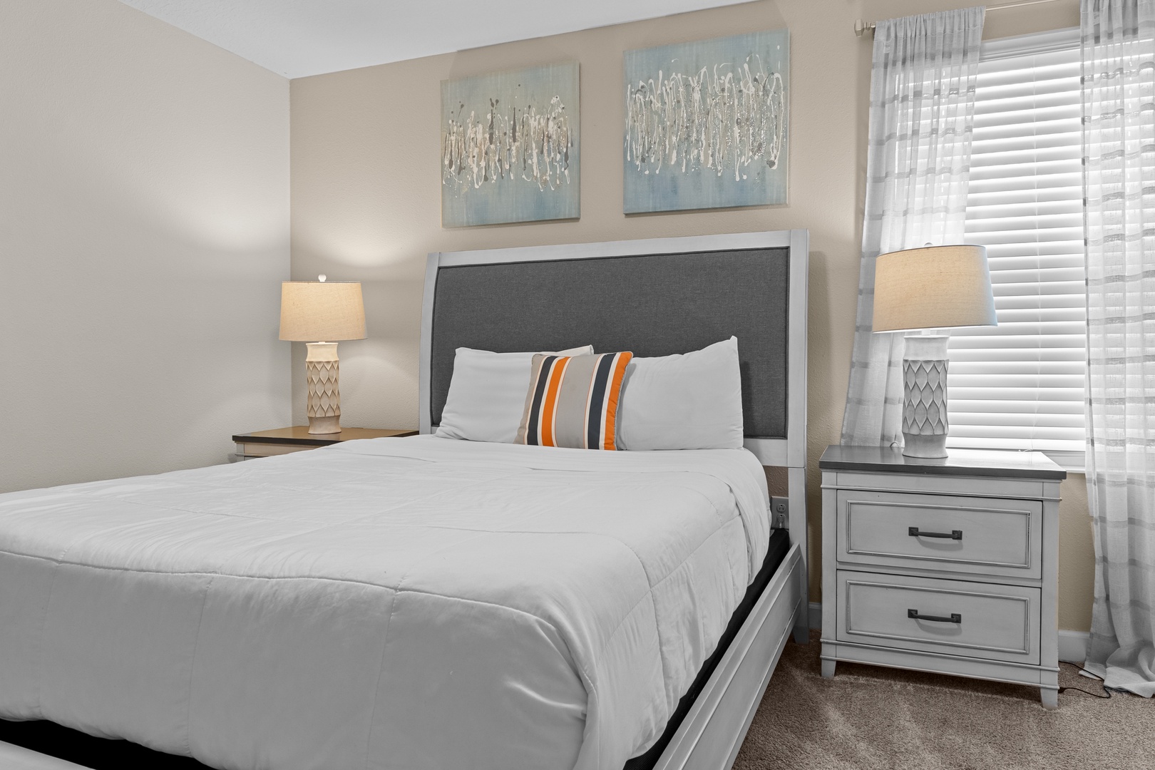 Rest peacefully in your comfortable bedroom with crisp linens, warm lighting, and serene coastal artwork.