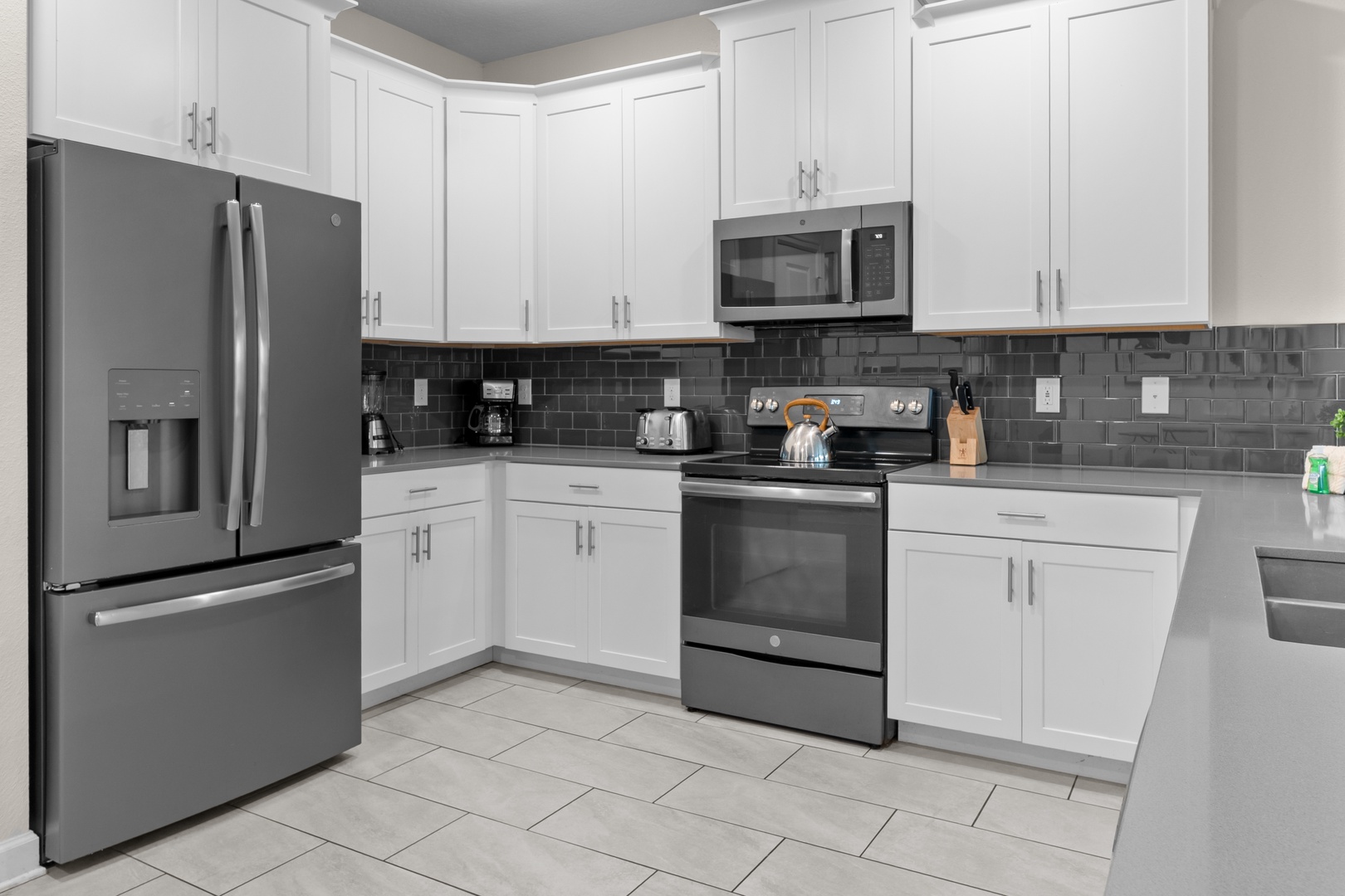 Your fully equipped kitchen awaits with modern stainless steel appliances and sleek white cabinets for all your culinary adventures.
