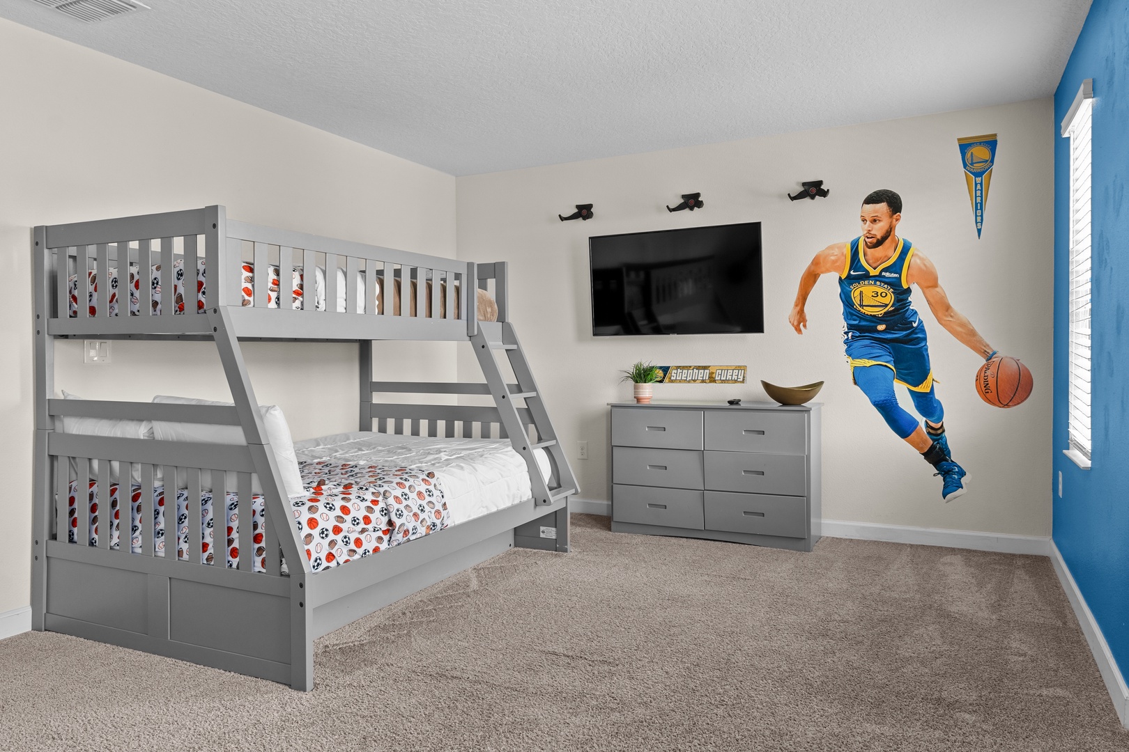Your kids will love this basketball-themed bedroom with twin-over-full bunk beds and their favorite player on the wall.