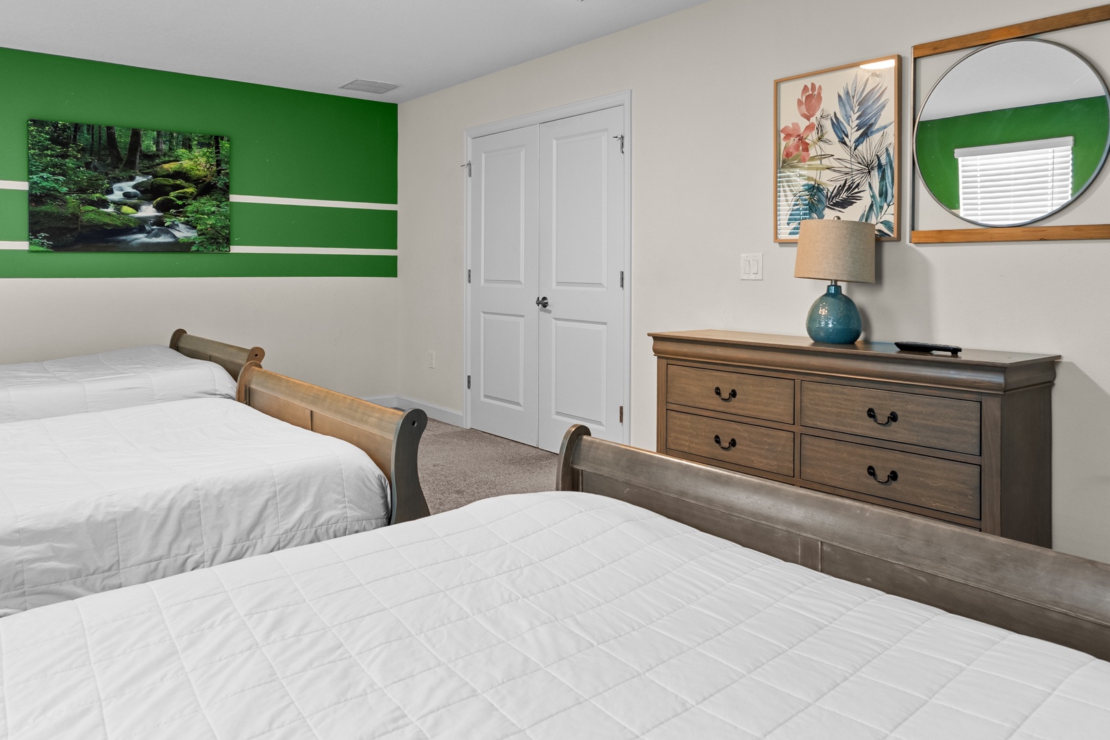 Rest peacefully in this serene twin bedroom featuring crisp white linens, warm wood furnishings, and calming nature artwork that sets the perfect tone for relaxation.