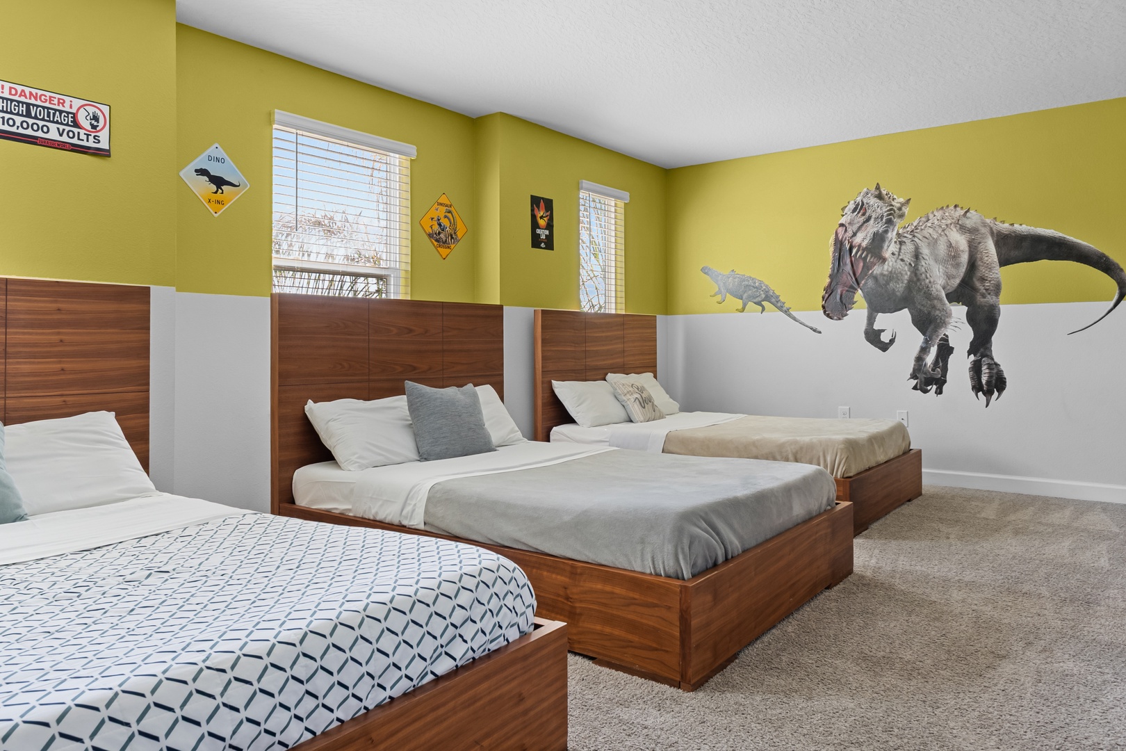 Your kids will roar with excitement in this dinosaur-themed bedroom featuring three cozy beds and playful prehistoric wall art.