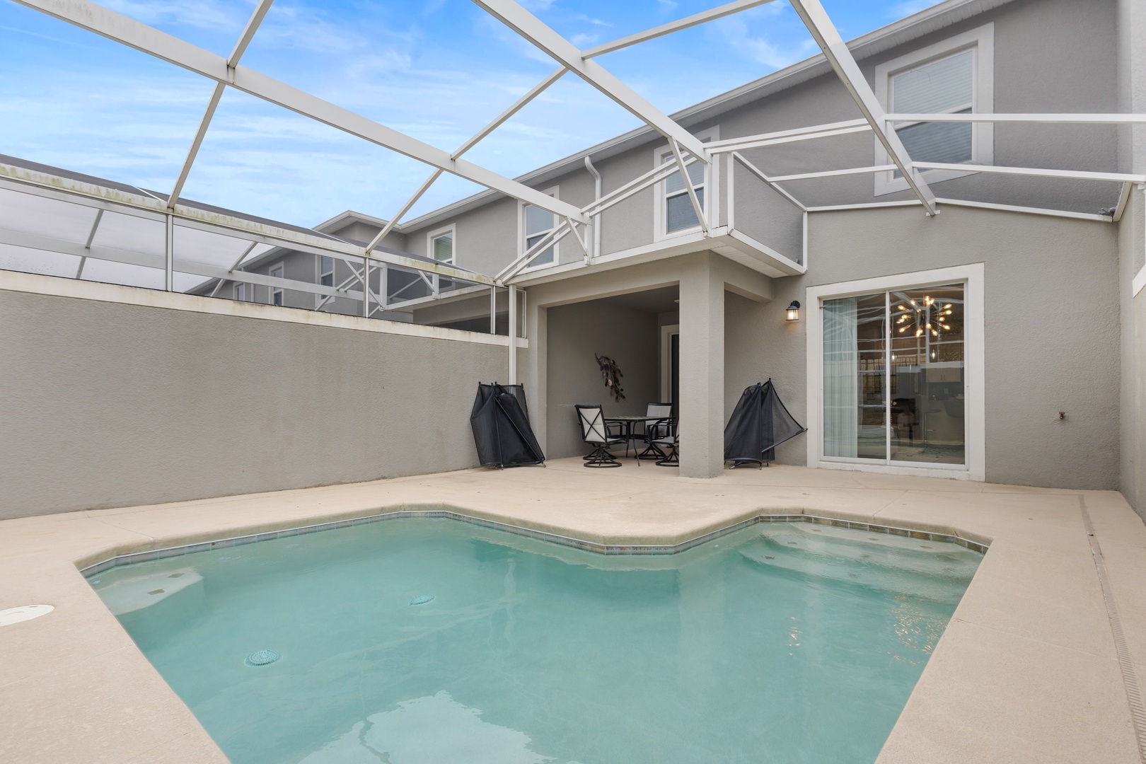 Your private screened pool awaits with sparkling waters and comfortable poolside seating for perfect relaxation.