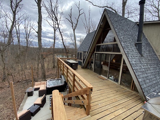 The picturesque deck surrounded by the woods overlooks the patio area.