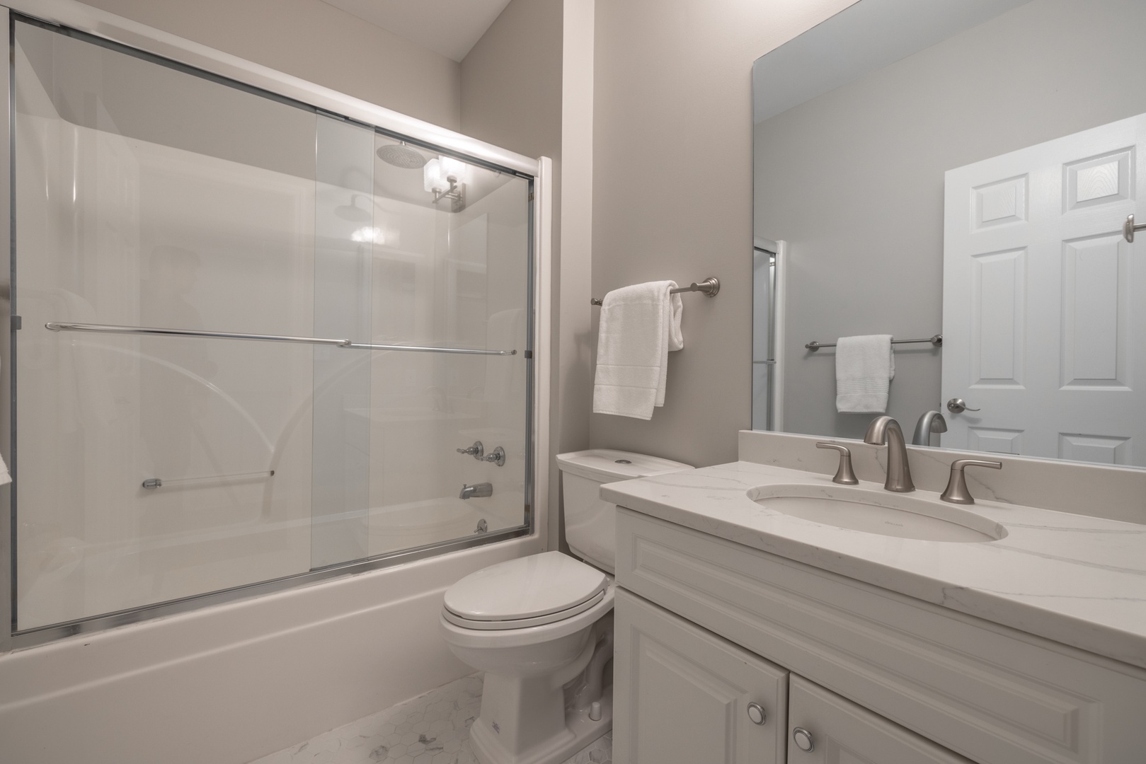 Sleek and pristine full bathroom on the main level