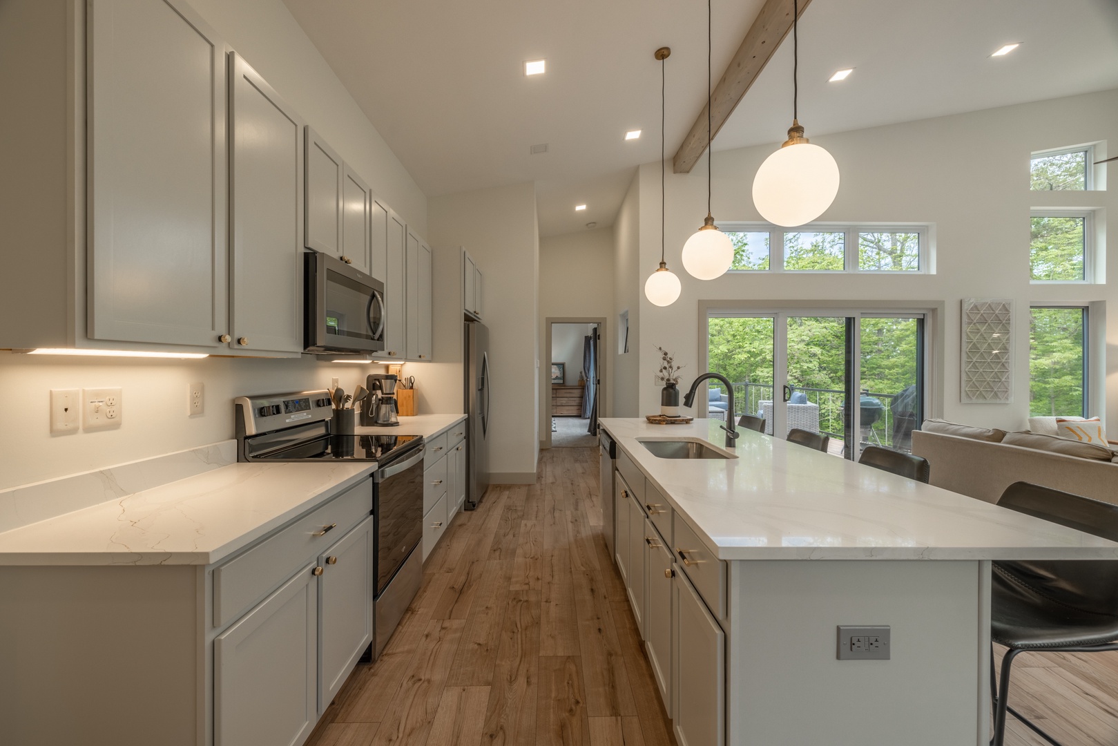 The fully equipped kitchen features beautiful quartz countertops, Whirlpool 30" electric range stove, 36" stainless steel side-by-side refrigerator with water and ice dispenser, heavy-duty dishwasher, microwave, and shaker style cabinets with soft close
