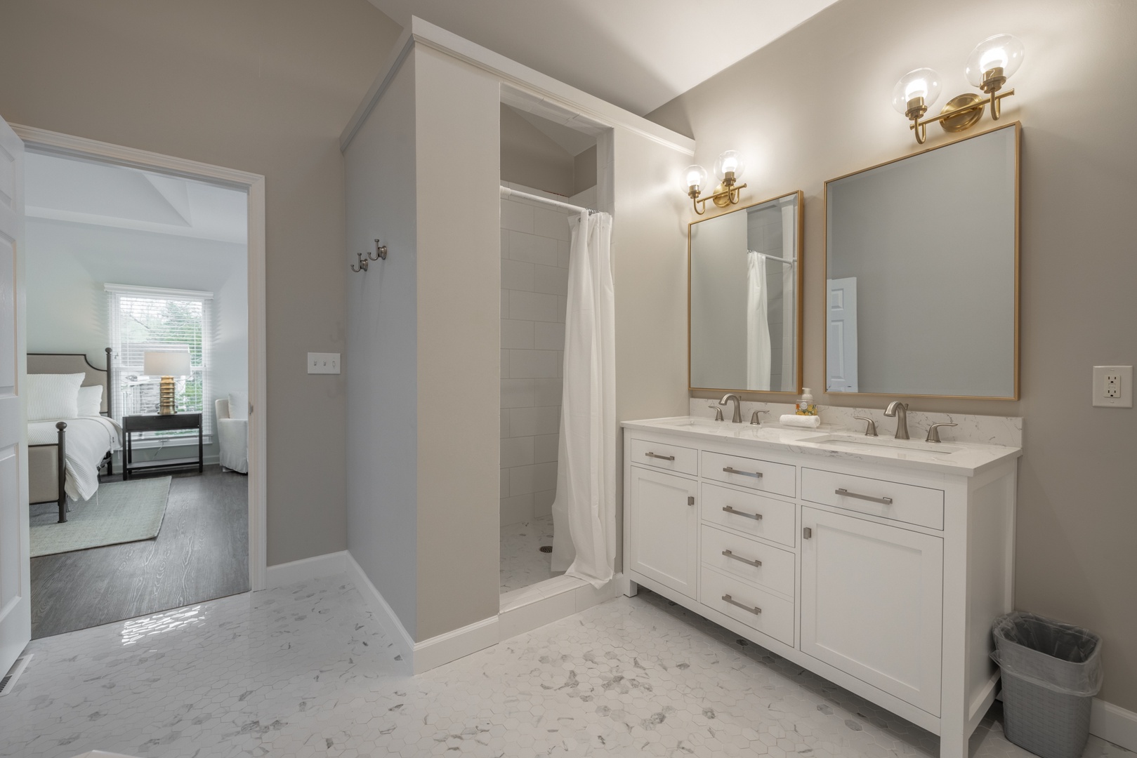 Pristine flooring, a stand alone shower, double vanities, and an oversized jetted tub scream luxury in the en suite primary bathroom