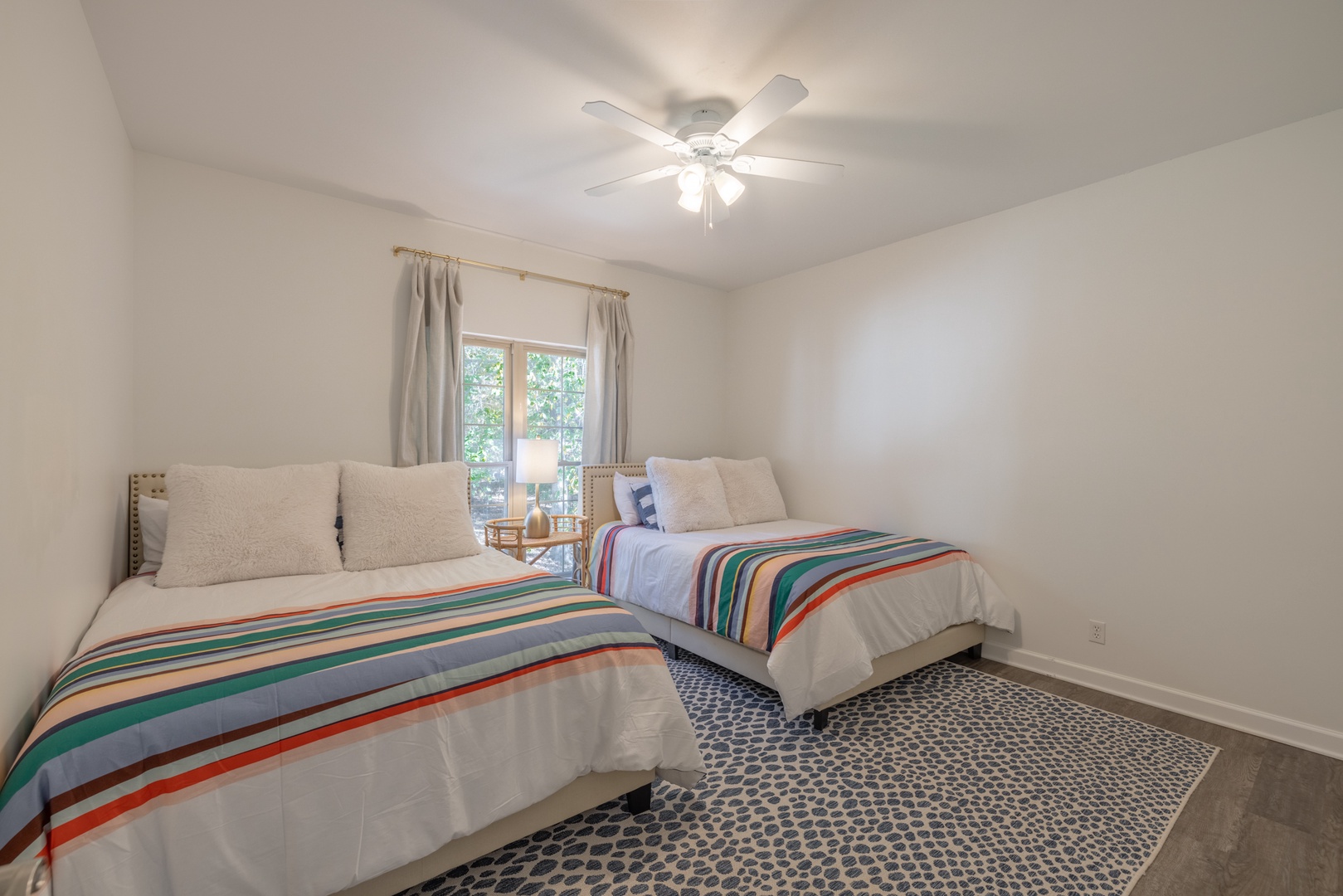 Modern décor continues in the guest bedroom, boasting two queen beds and expansive windows