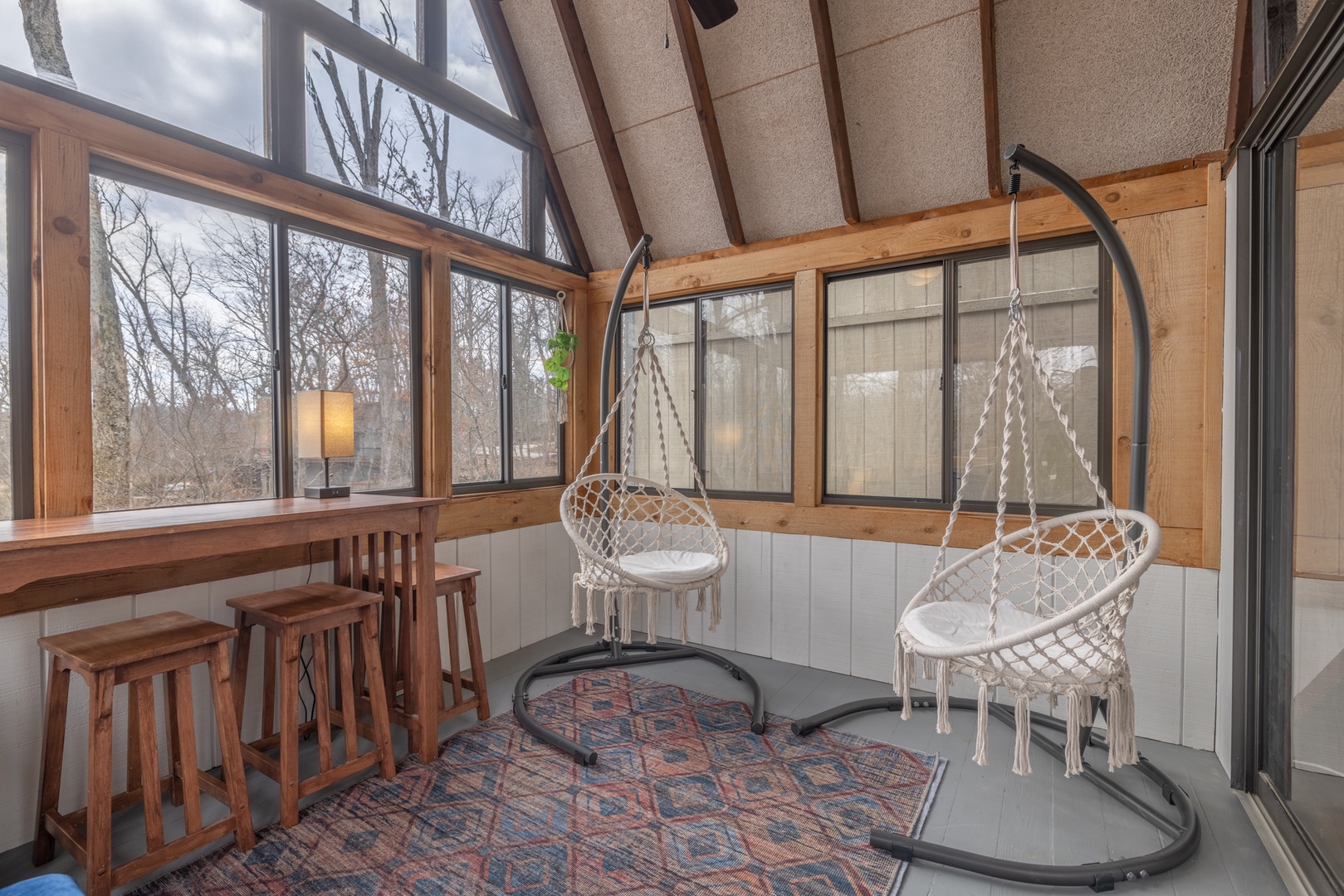 The sunroom is a perfect place to relax with a loved one as you share the pair of hanging chairs.