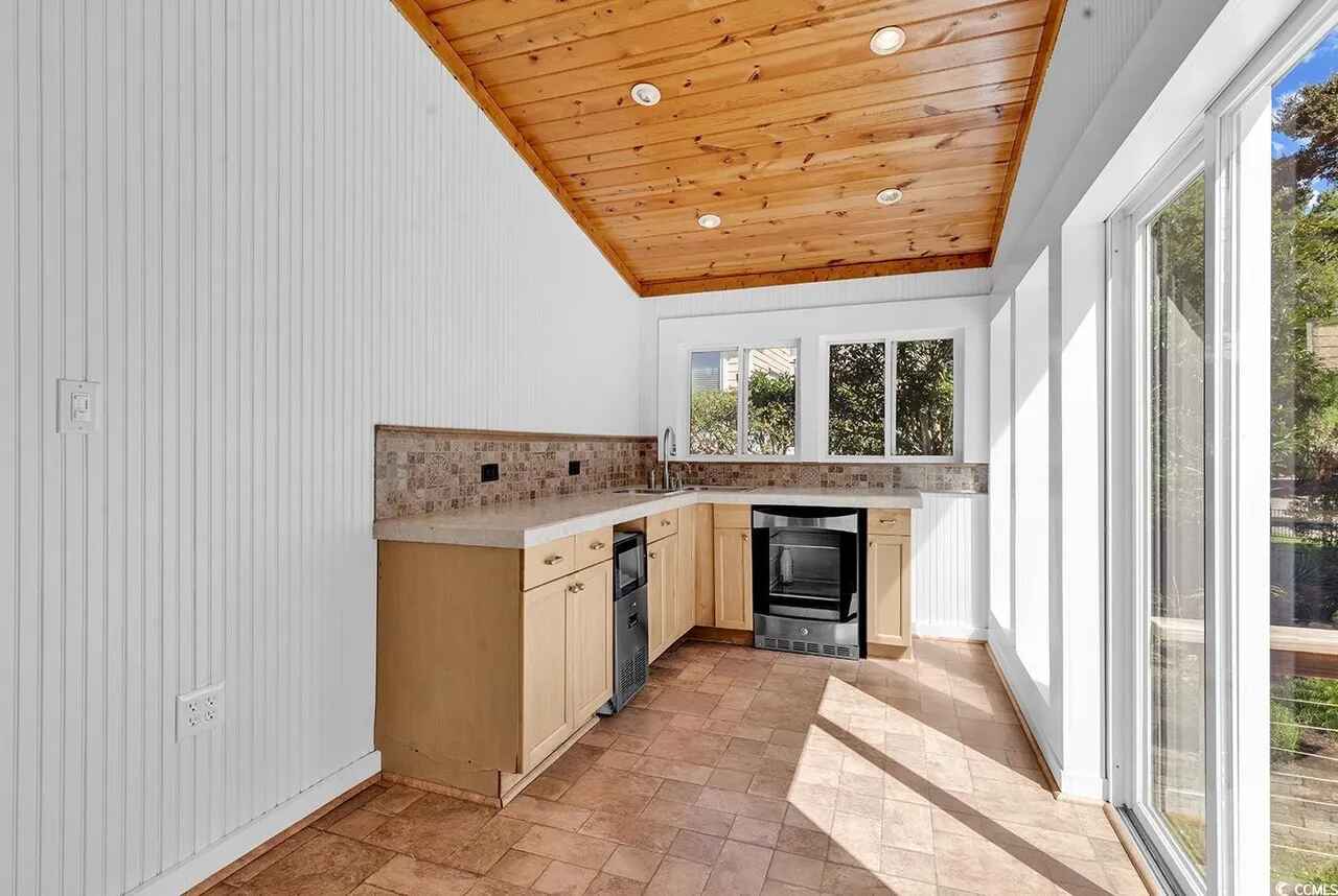 Your bright kitchen features warm wood ceiling, natural light, and modern appliances for memorable meals.