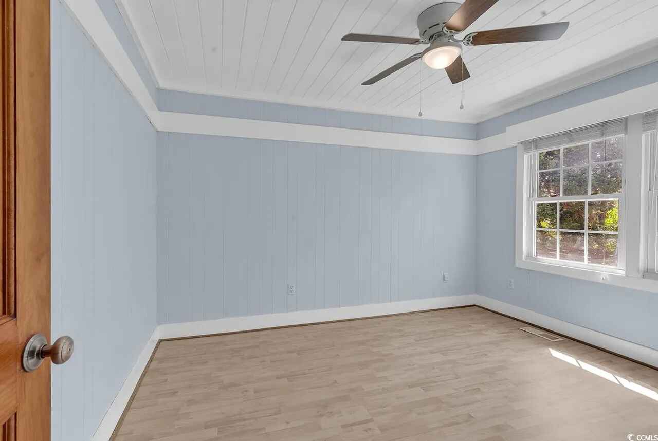 Relax in your spacious bedroom with charming blue walls, tray ceiling, and ceiling fan for perfect temperature control.