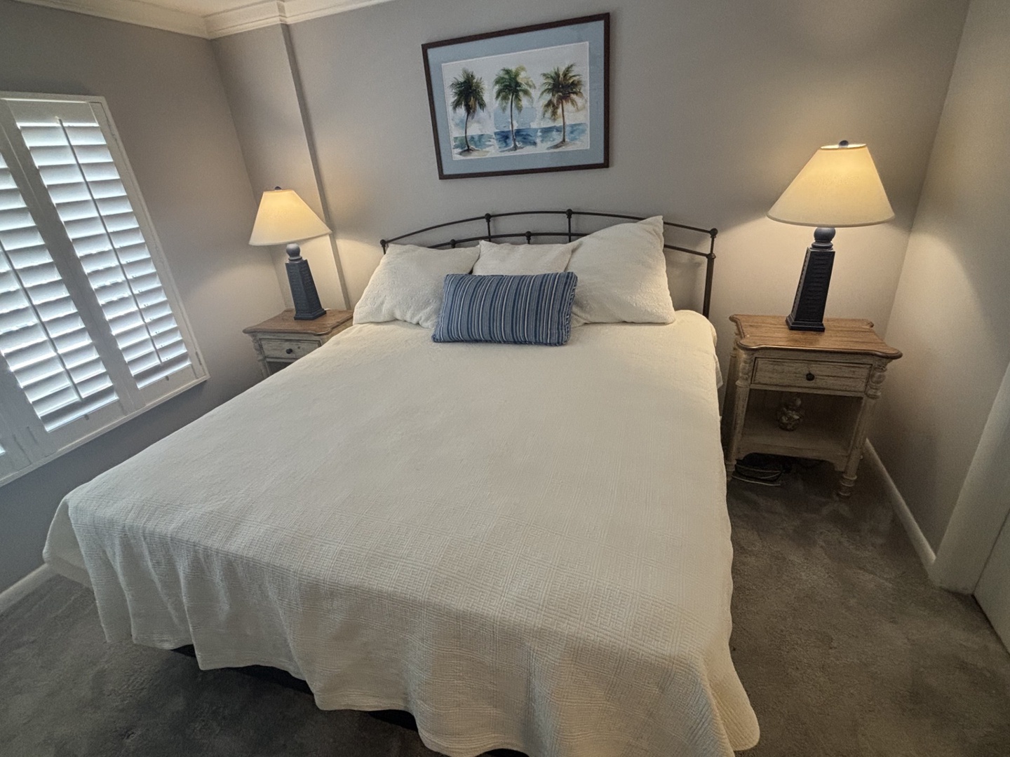 Drift into peaceful sleep in your cozy bedroom with soft linens, warm lighting, and tropical artwork creating the perfect retreat.