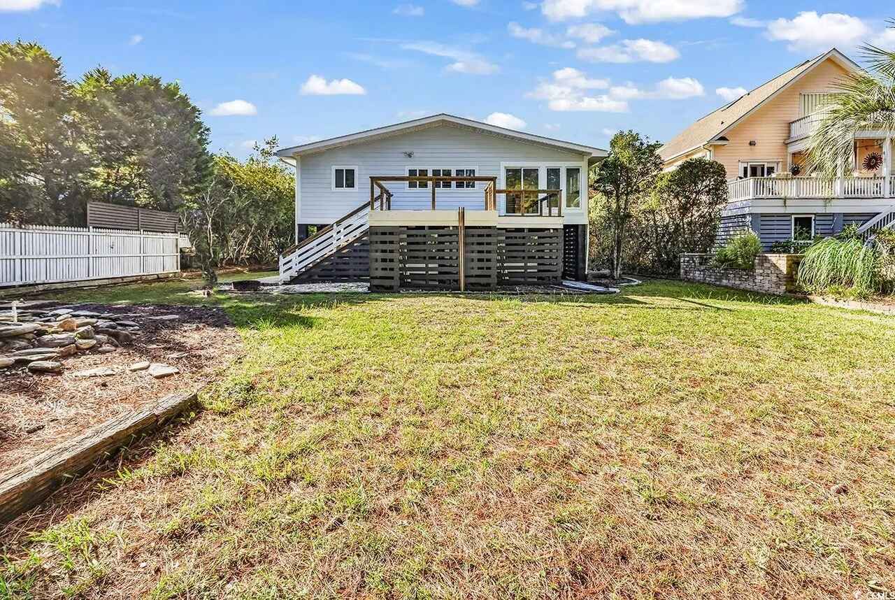 Charming elevated beach house with spacious yard, perfect for outdoor gatherings and relaxation in this peaceful coastal neighborhood.