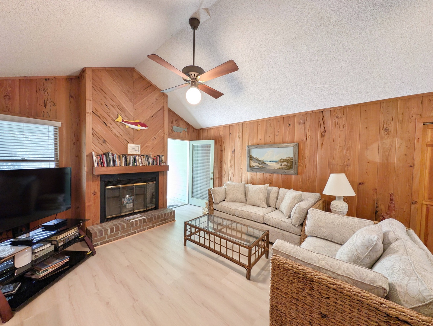Relax in your spacious living room with vaulted ceilings, warm wood paneling, a cozy fireplace, and comfortable seating perfect for unwinding after your adventures.