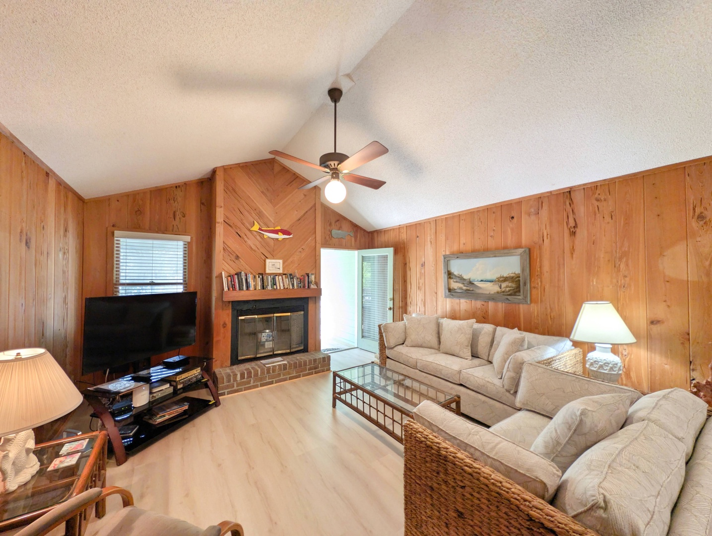 Sink into plush sofas beneath vaulted ceilings, where warm wood paneling and a cozy fireplace create your perfect retreat after a day of coastal adventures.