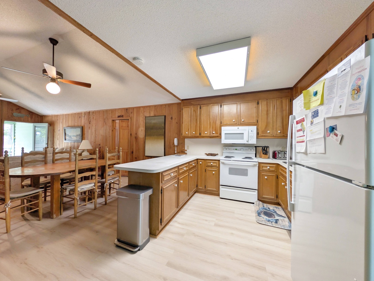 Your spacious open-concept kitchen and dining area features warm wood cabinetry, full-size appliances, and a large dining table perfect for gathering together after a day of adventure.