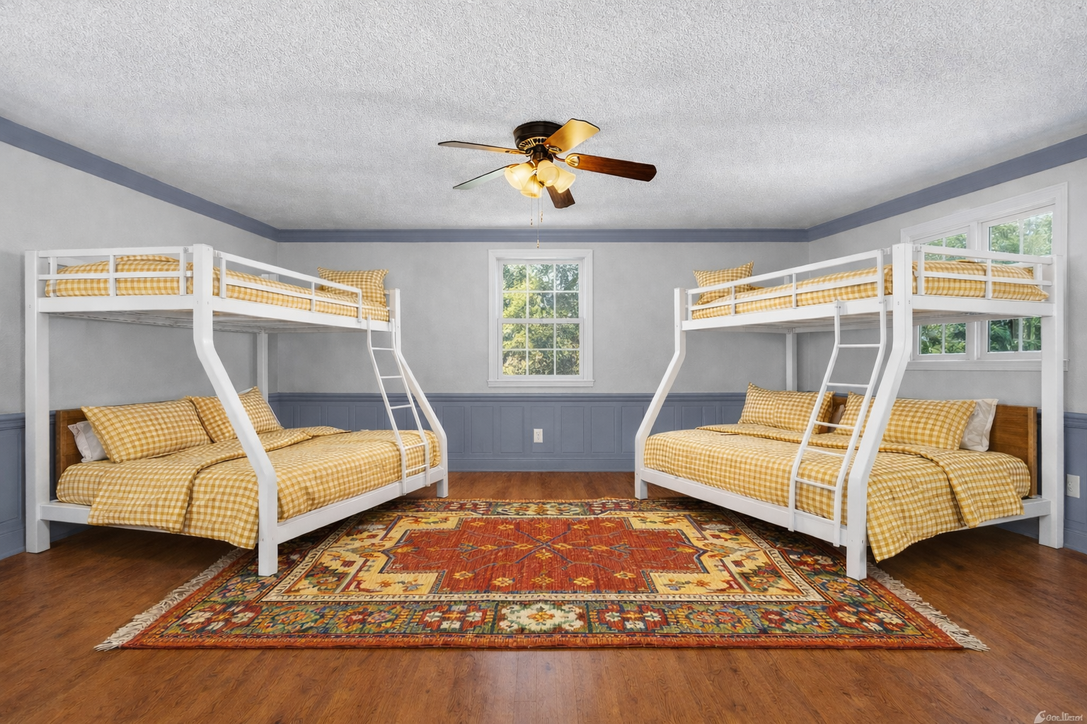 Sleep soundly in this cheerful bunk room where yellow gingham bedding and a colorful rug create a welcoming space for your group.