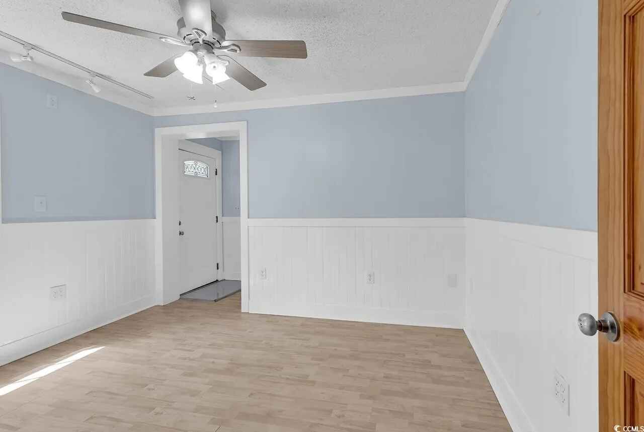 Step into your serene bedroom featuring soft blue walls, crown molding, and a ceiling fan to keep you comfortable year-round.