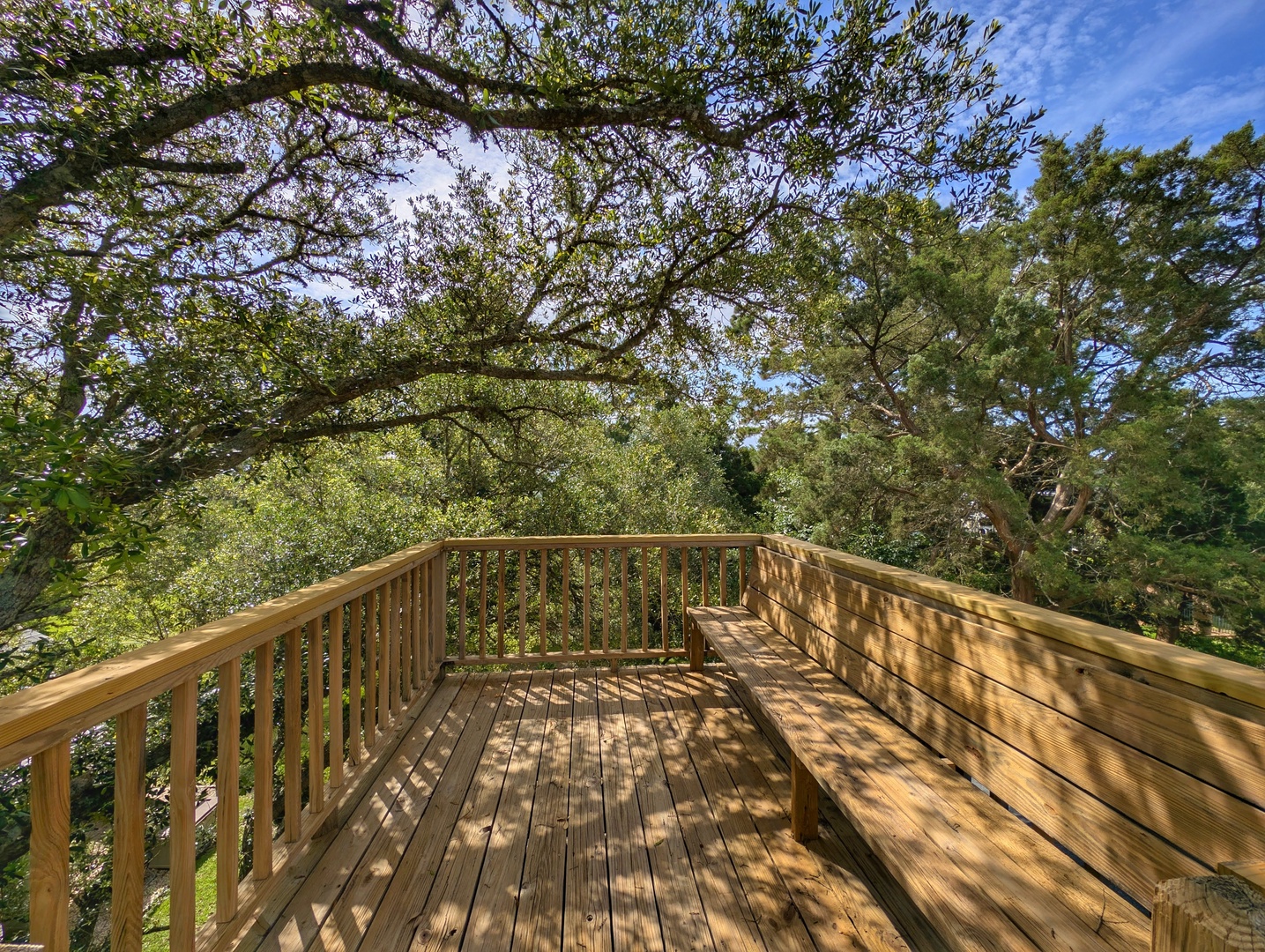 The property features a spacious wooden deck overlooking lush natural surroundings, providing a peaceful outdoor retreat for guests during their stay.
