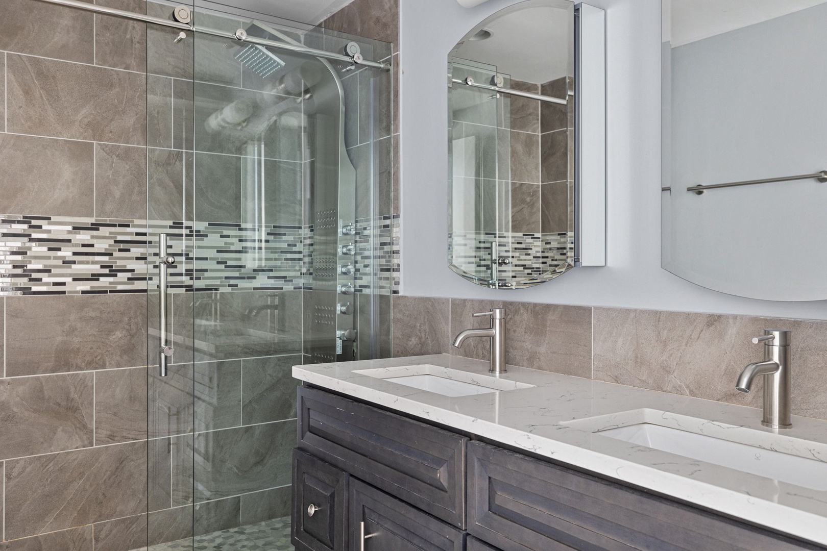 This beautifully designed bathroom features a spacious, tiled walk-in shower.