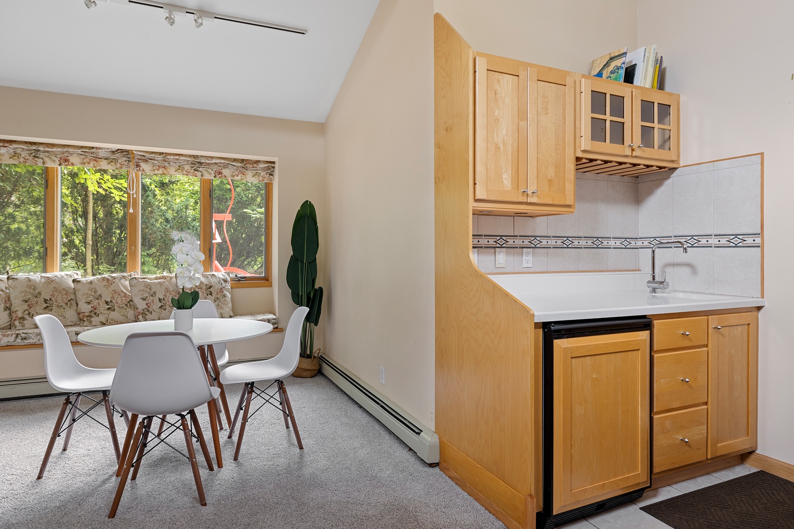 The wet bar and café table create a cozy spot for socializing.