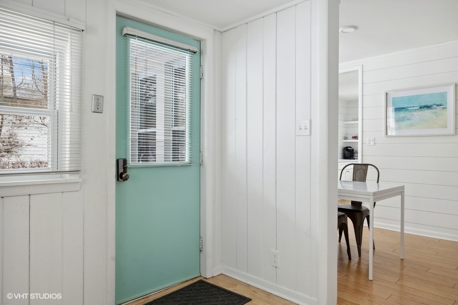The turquoise front door and warm, natural light create an inviting entryway.