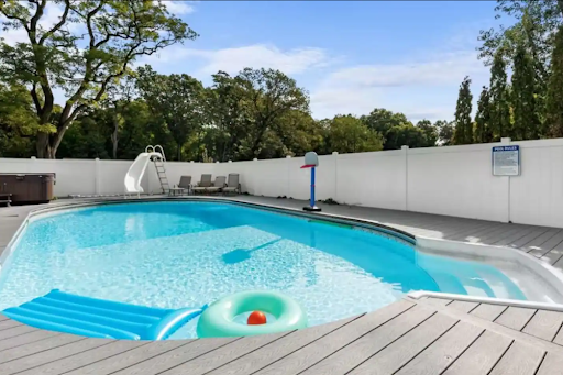 A pool with a wraparound deck, a water slide and chaise lounges galore-Oh yeah!