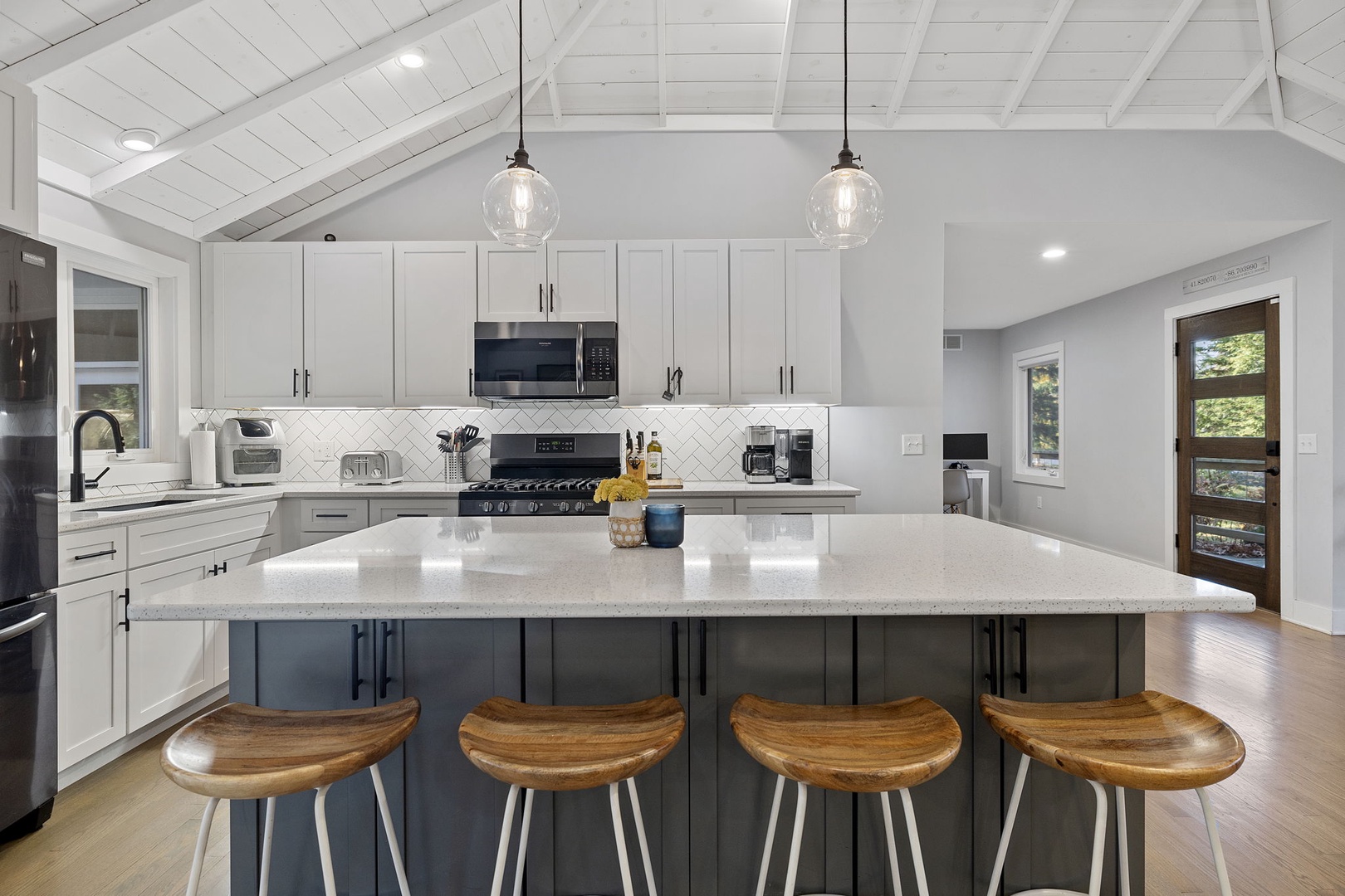 The wraparound kitchen with a handsome central island is a cool gathering spot.