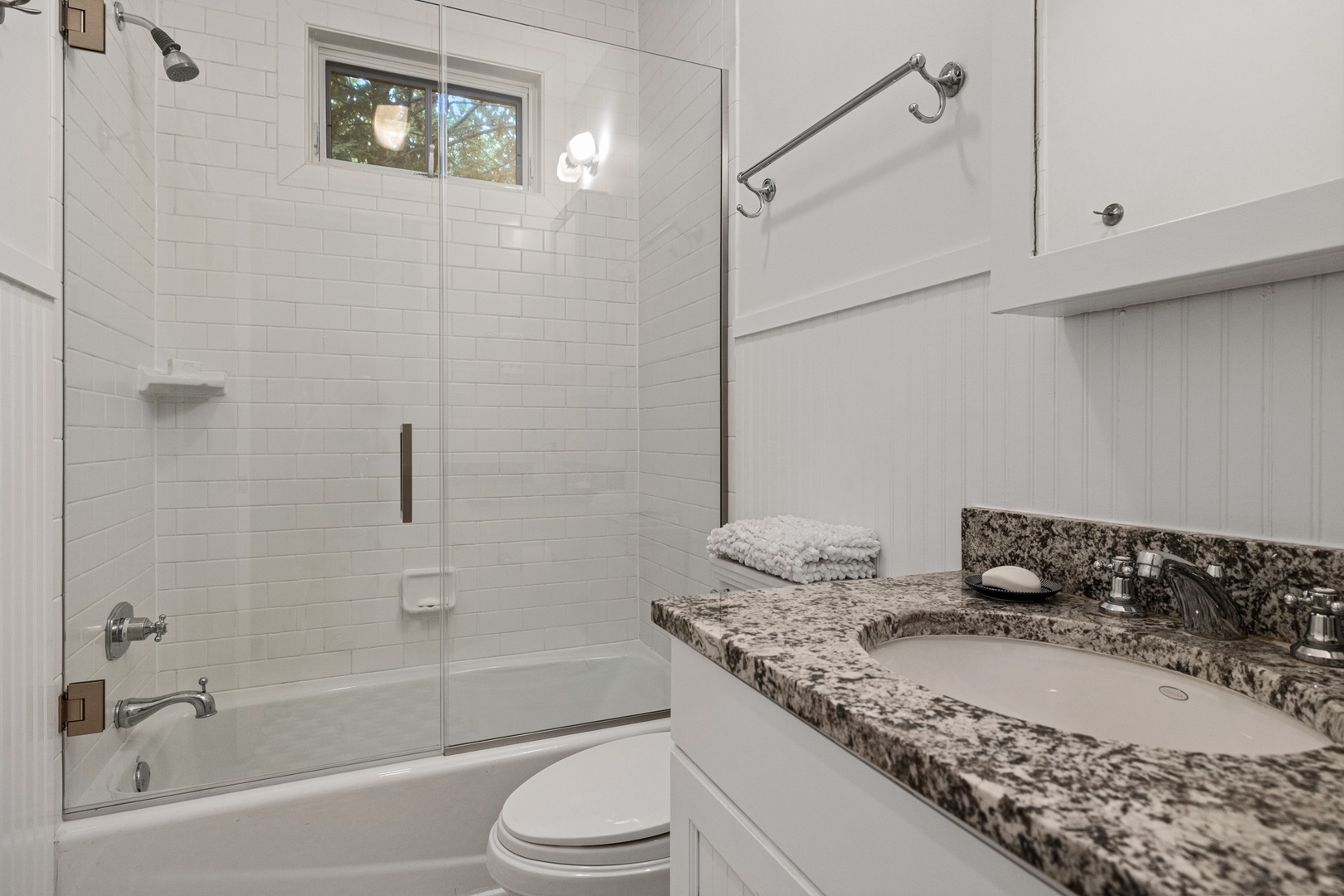 Our full bath features a granite-topped sink and tiled shower.