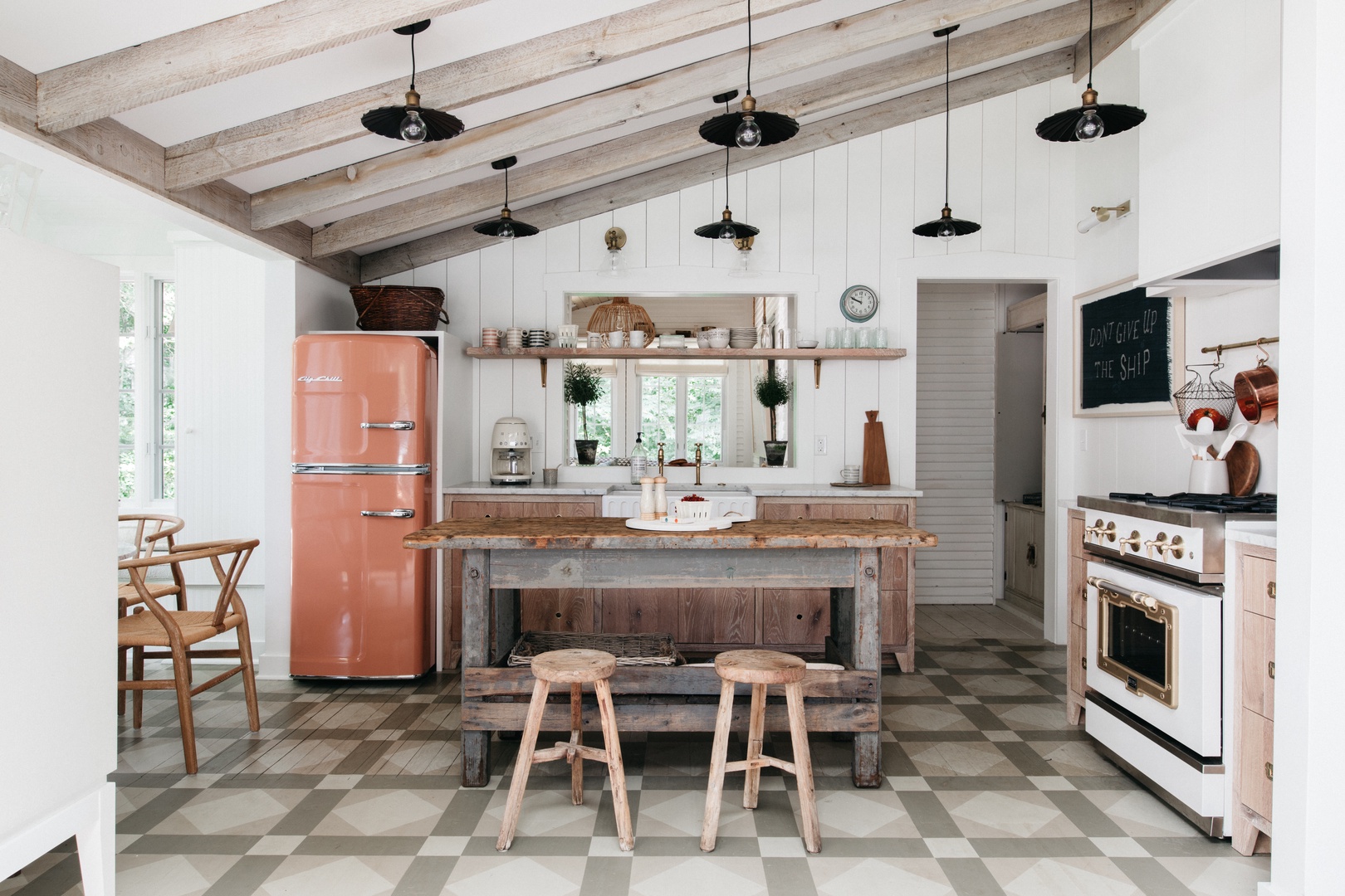 The well-equipped kitchen includes a center prep island with bar stools for entertaining,