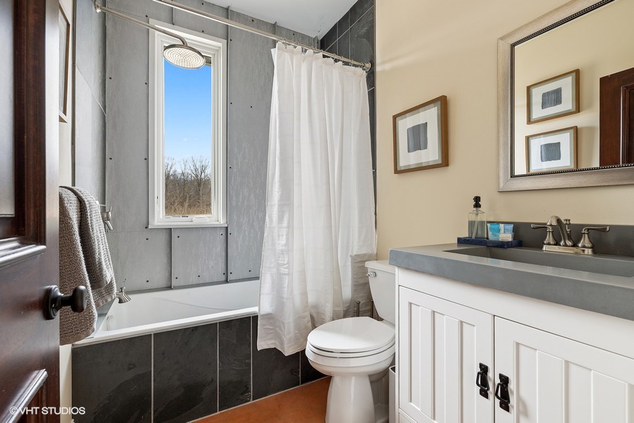 Both guest baths have a classic design, handsome wooden, cabinetry and high-quality fixtures.