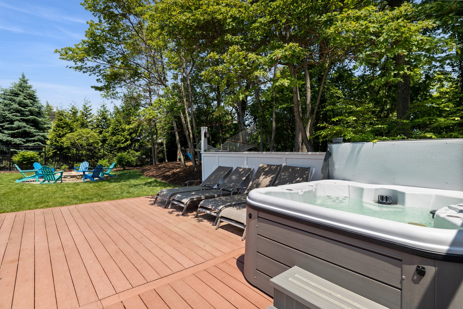 Surrounded by lush greenery, the hot tub offers a peaceful spot to relax and unwind.