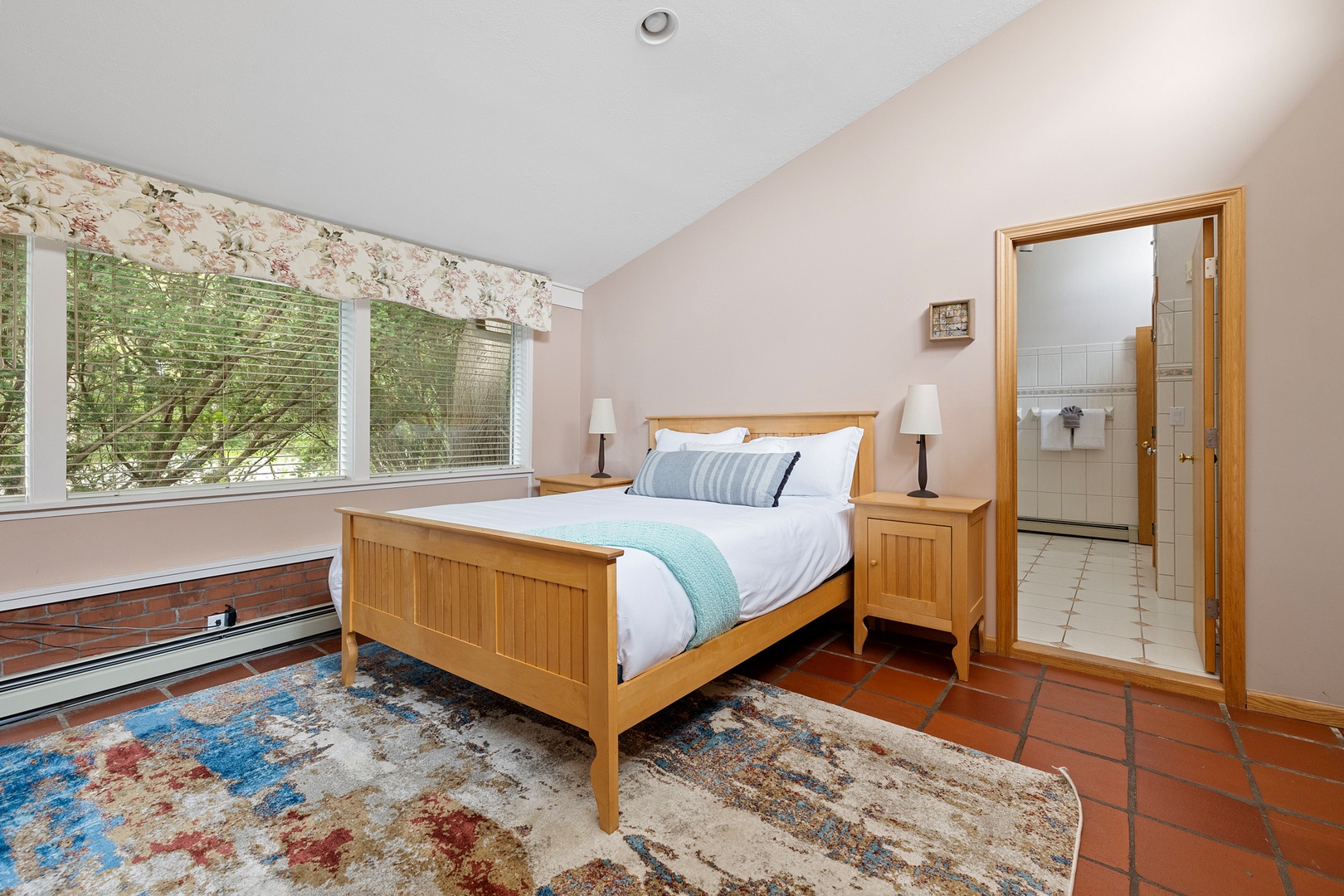 The spacious primary bedroom features a comfortably queen bed and ensuite bathroom.
