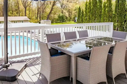 Enjoy a meal outside on the deck, with its rich rattan + glass dining table.