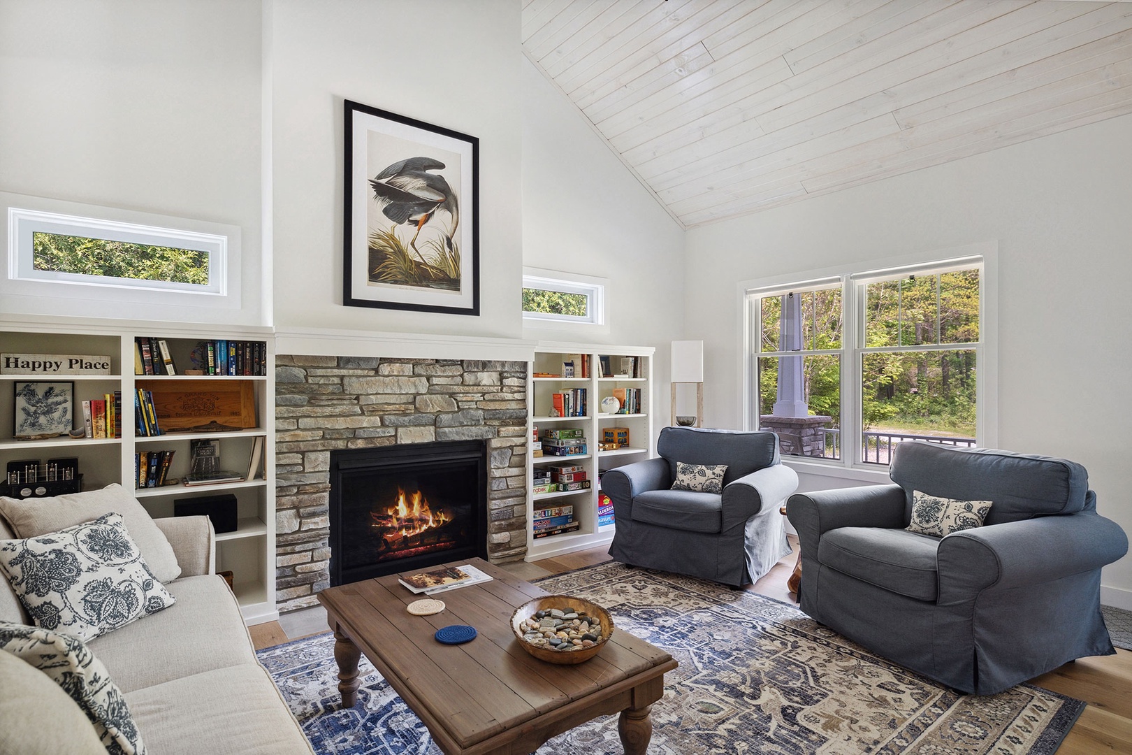 Lounge in the cozy living area with stone-trimmed fireplace in chillier weather.